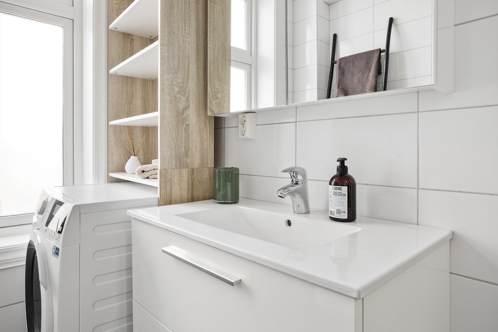 De gråfargede og delikate gulvflisene skaper en lun kontrast til de klassiske og lysere veggflisene i hvitt. Galleribilde