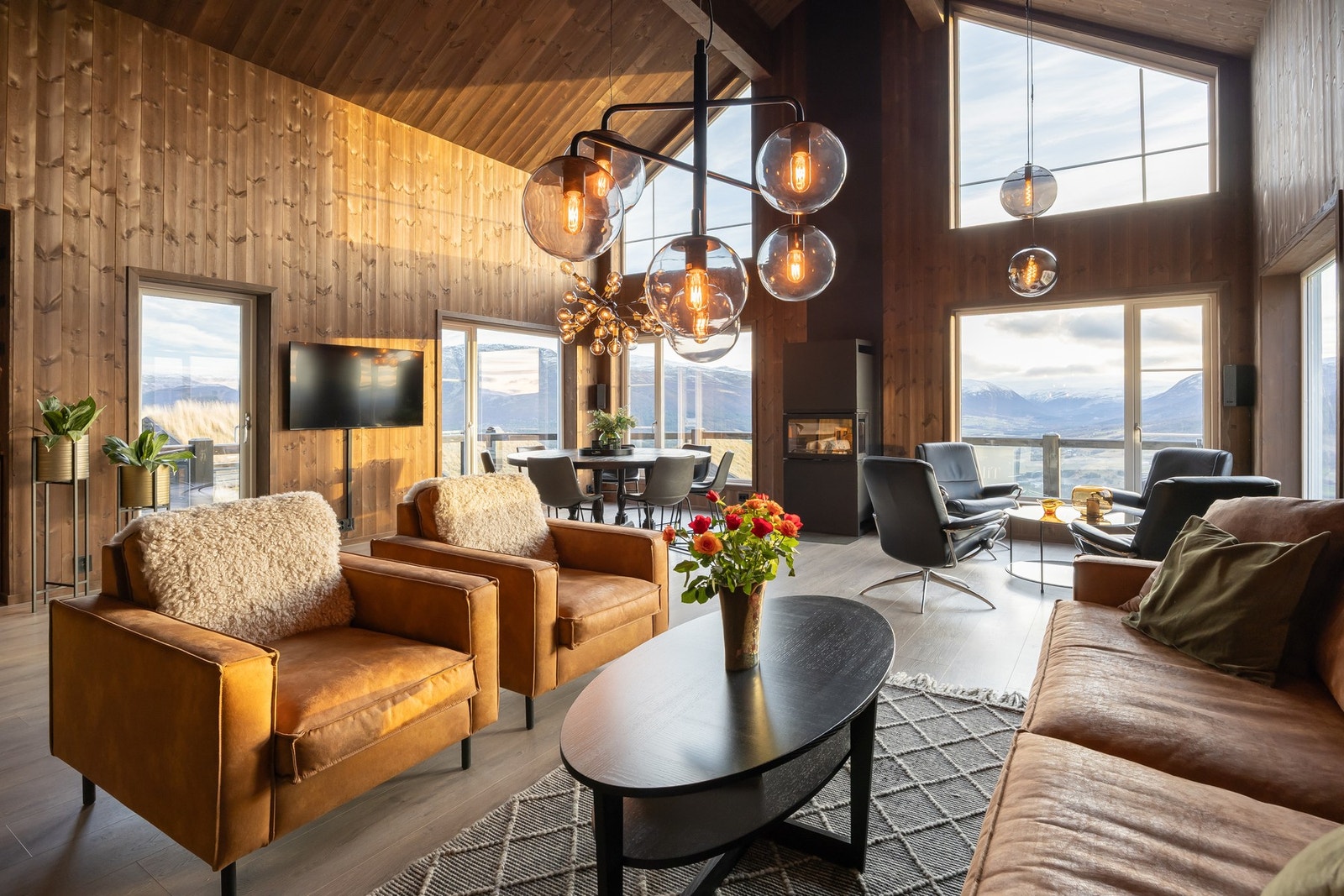 ra entréen ankommer man en luftig og elegant stue. Her er det store vindusflater som strekker seg helt opp mot mønet og slipper inn rikelig med naturlig lys.