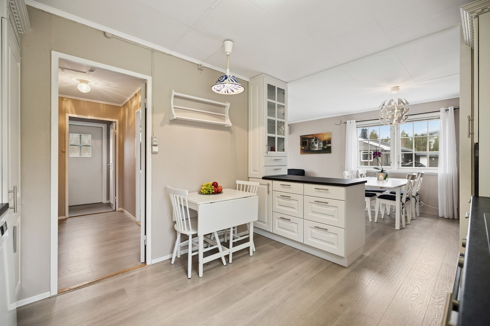 Kjøkkenet har en praktisk halvøy som gir ekstra benkeplass og deler av rommet på en smart måte. Galleribilde