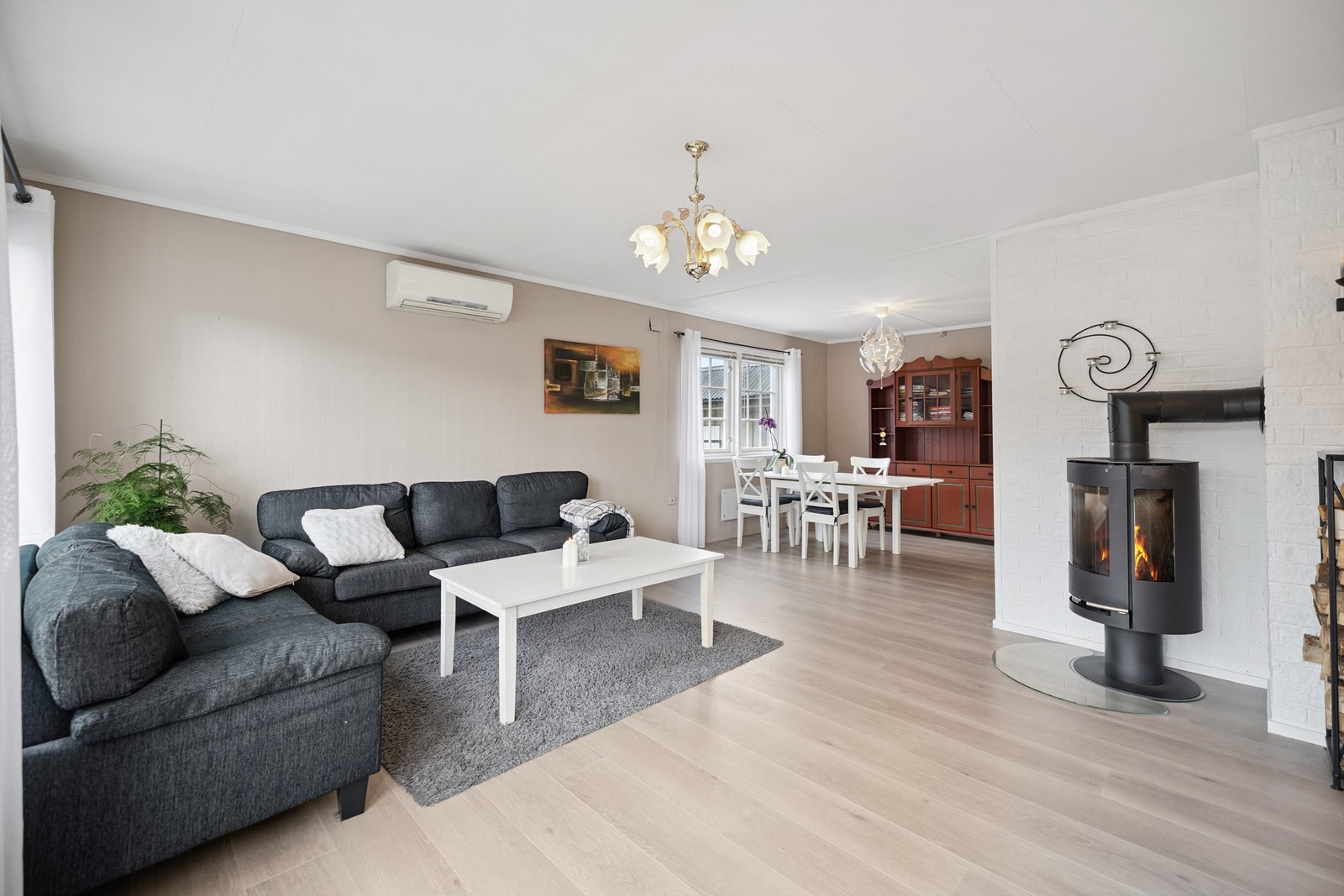 En moderne vedovn gir både varme og en hyggelig atmosfære i stuen. Det er i tillegg installert varmepumpe. Galleribilde