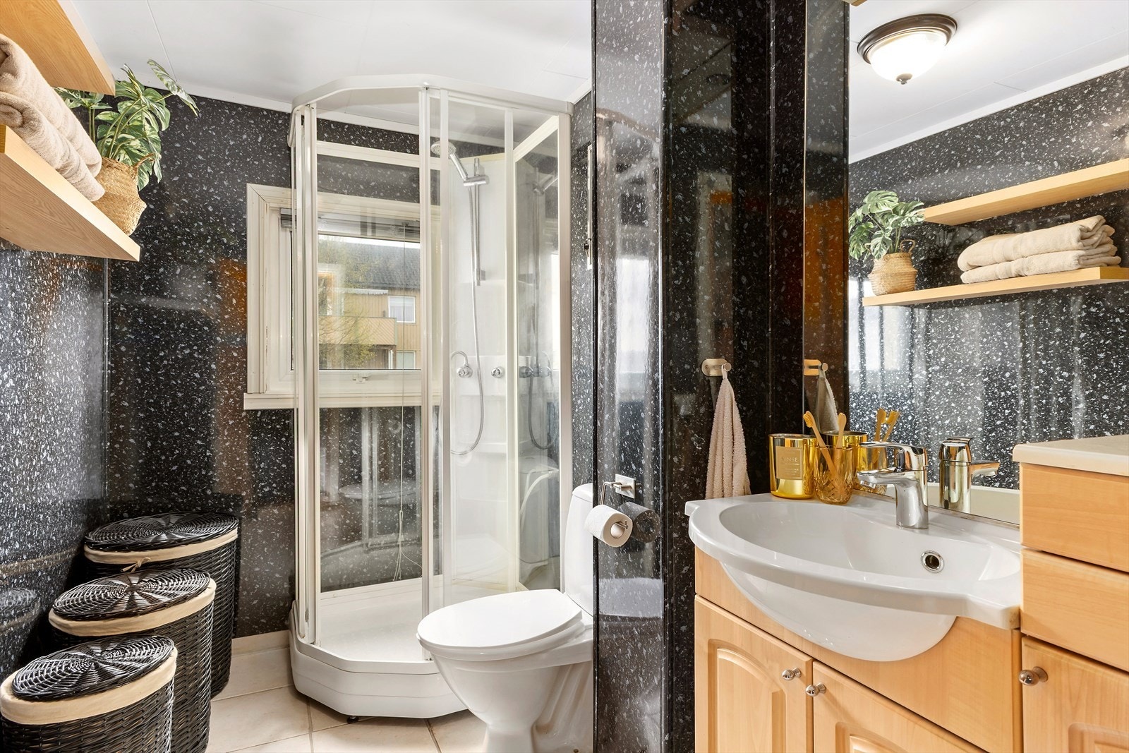 Badet er godt arealutnyttet og innredet med dusjkabinett, toalett og baderomsinnredning. Galleribilde