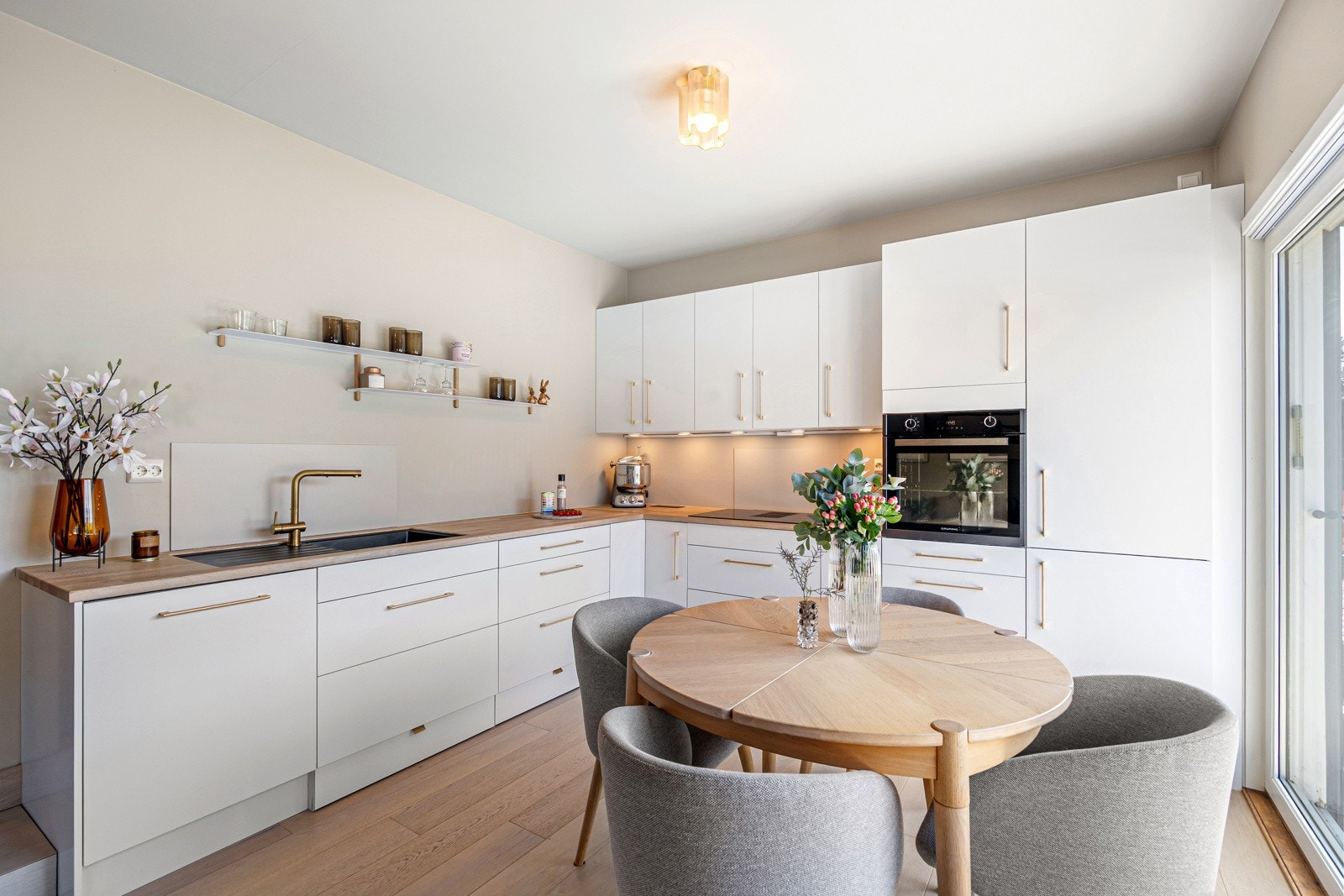 Intergrert stekeovn, platetopp med nedfelt ventilator, oppvaskmaskin og kombiskap som medfølger i handelen. Galleribilde