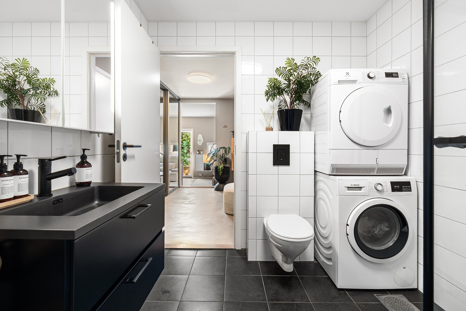 Lekkert helfliset bad med moderne innredning, vegghengt toalett, dusjhjørne og god lagringsplass. Videre har badet opplegg for vaskemaskin og tørketrommel, samt varmekabler i gulv. Galleribilde