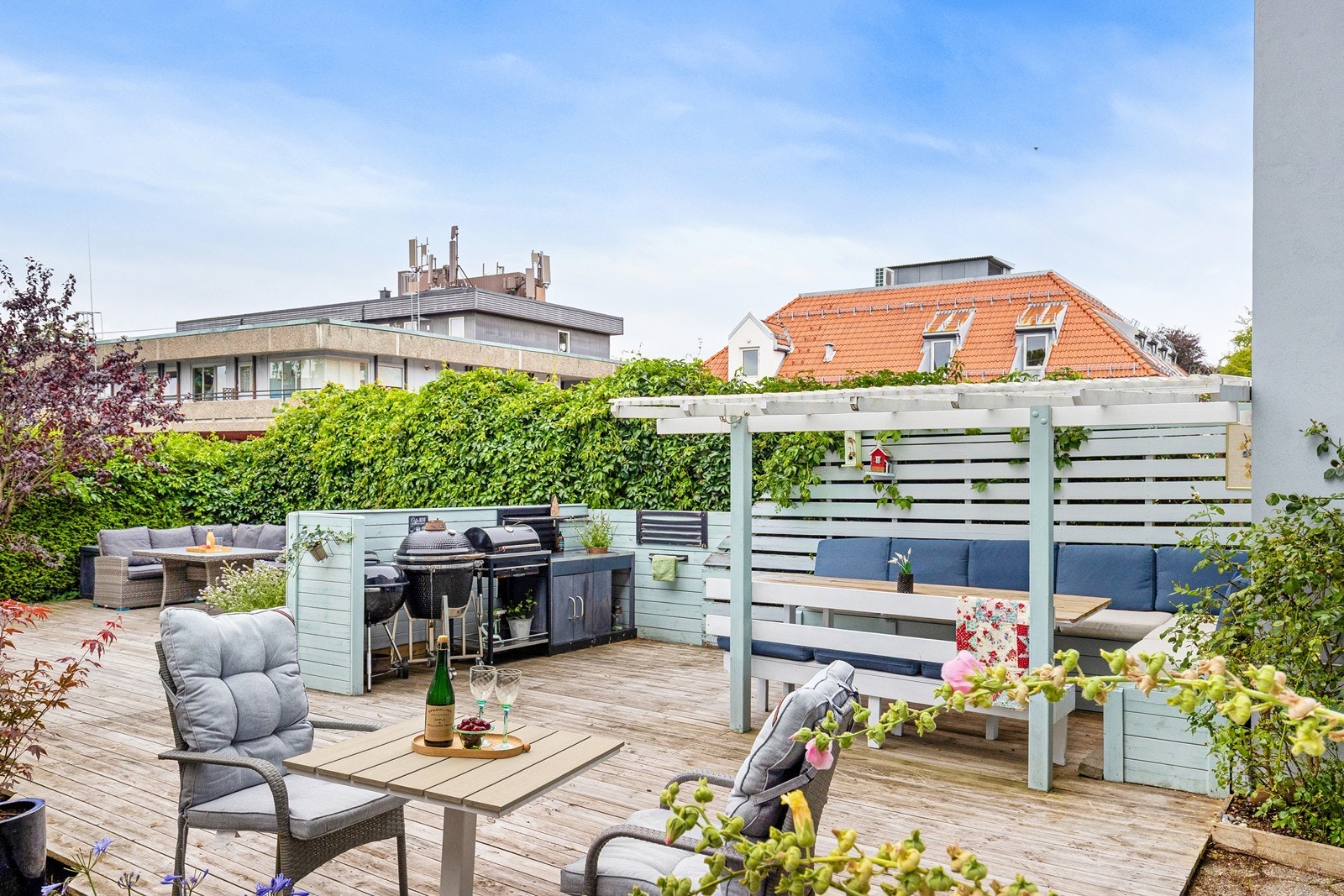 Flott og solrik felles uteplass med møbler og grill for beboernes bruk Galleribilde