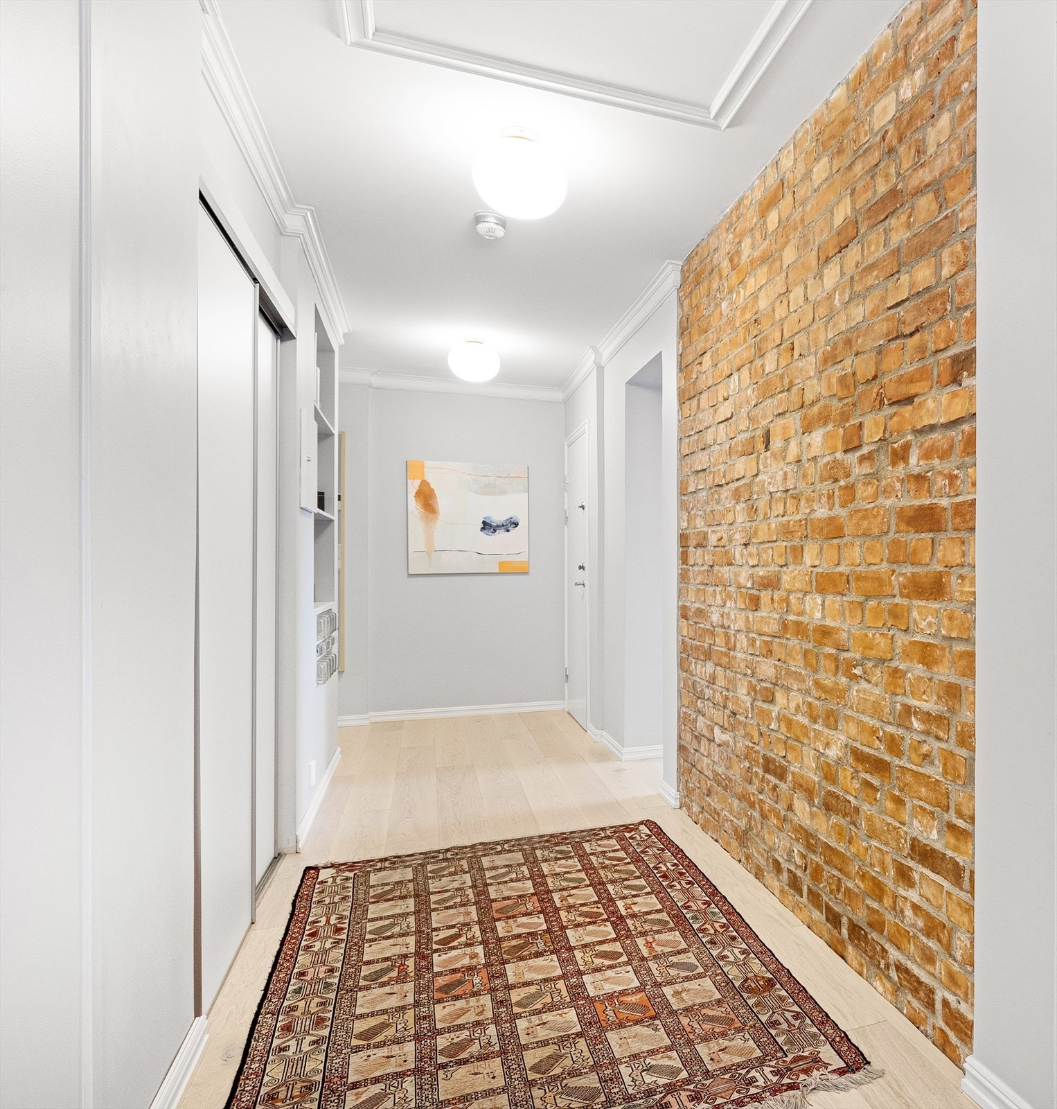 Lys og god entré/gang med integrert skyvedørsgarderobe. Original teglsteinsvegg, som gir en lun atmosfære Galleribilde