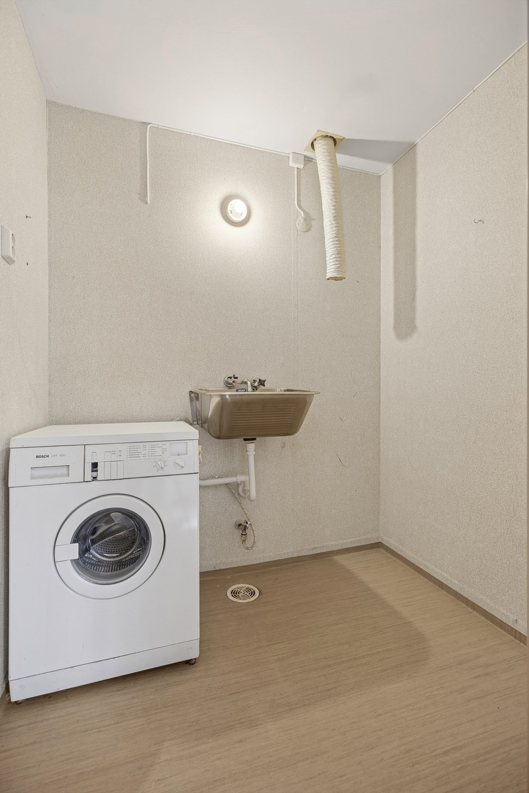 Vaskerommet har adkomst fra gang og er fra byggeåret. Rommet er utstyrt med plastsluk fra byggeåret og har opplegg for vaskemaskin og utslagsvask i stål. Galleribilde