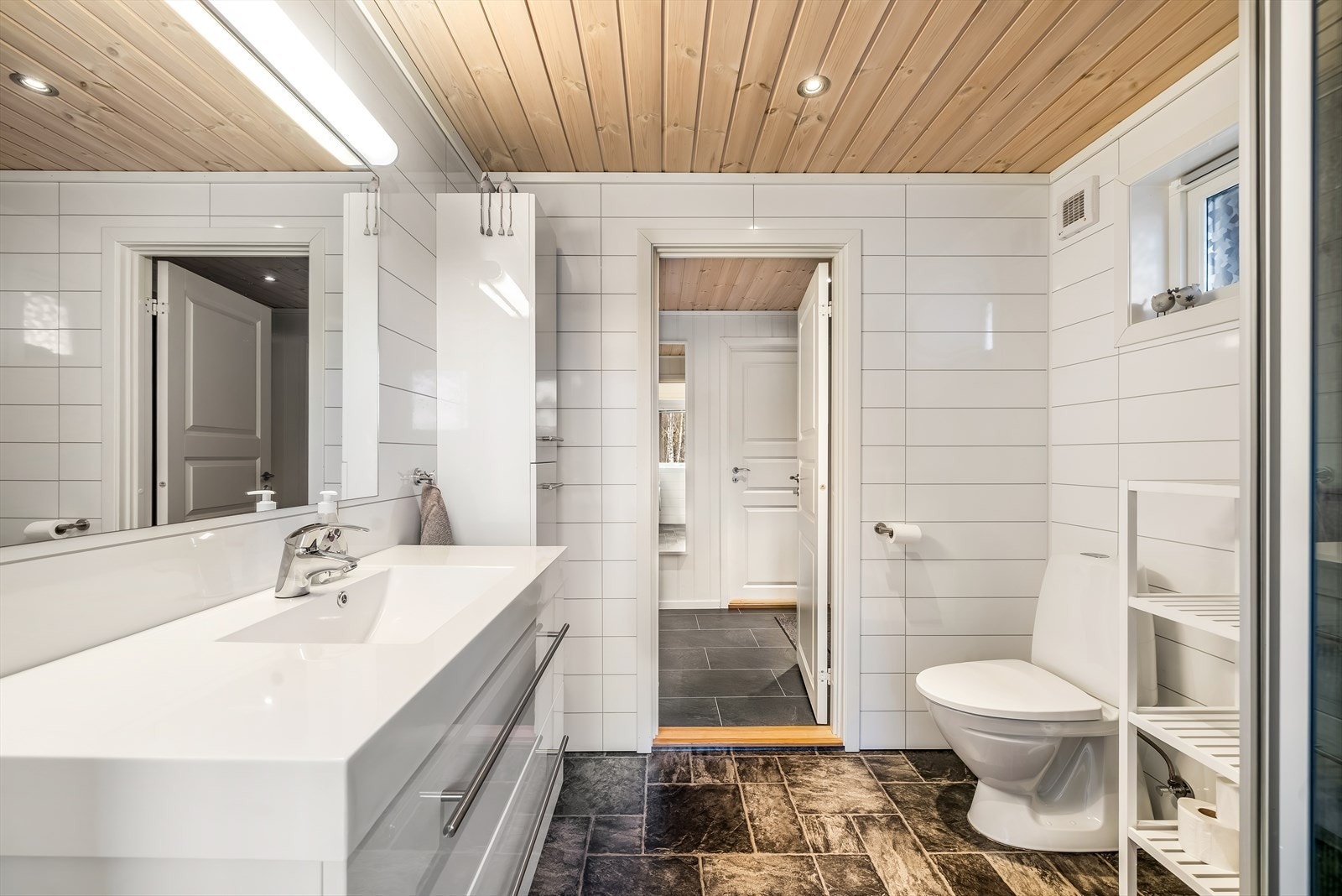 Romslig bad med servant, toalett og praktisk oppbevaring. Galleribilde