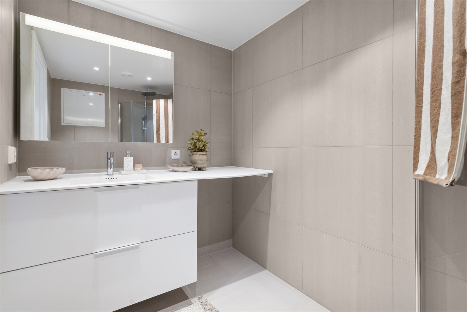 Lekkert flislagt (60x60) bad i 2.etg med opplegg til vaskemaskin, innredning med skuffer og overskap med speil og lys Galleribilde