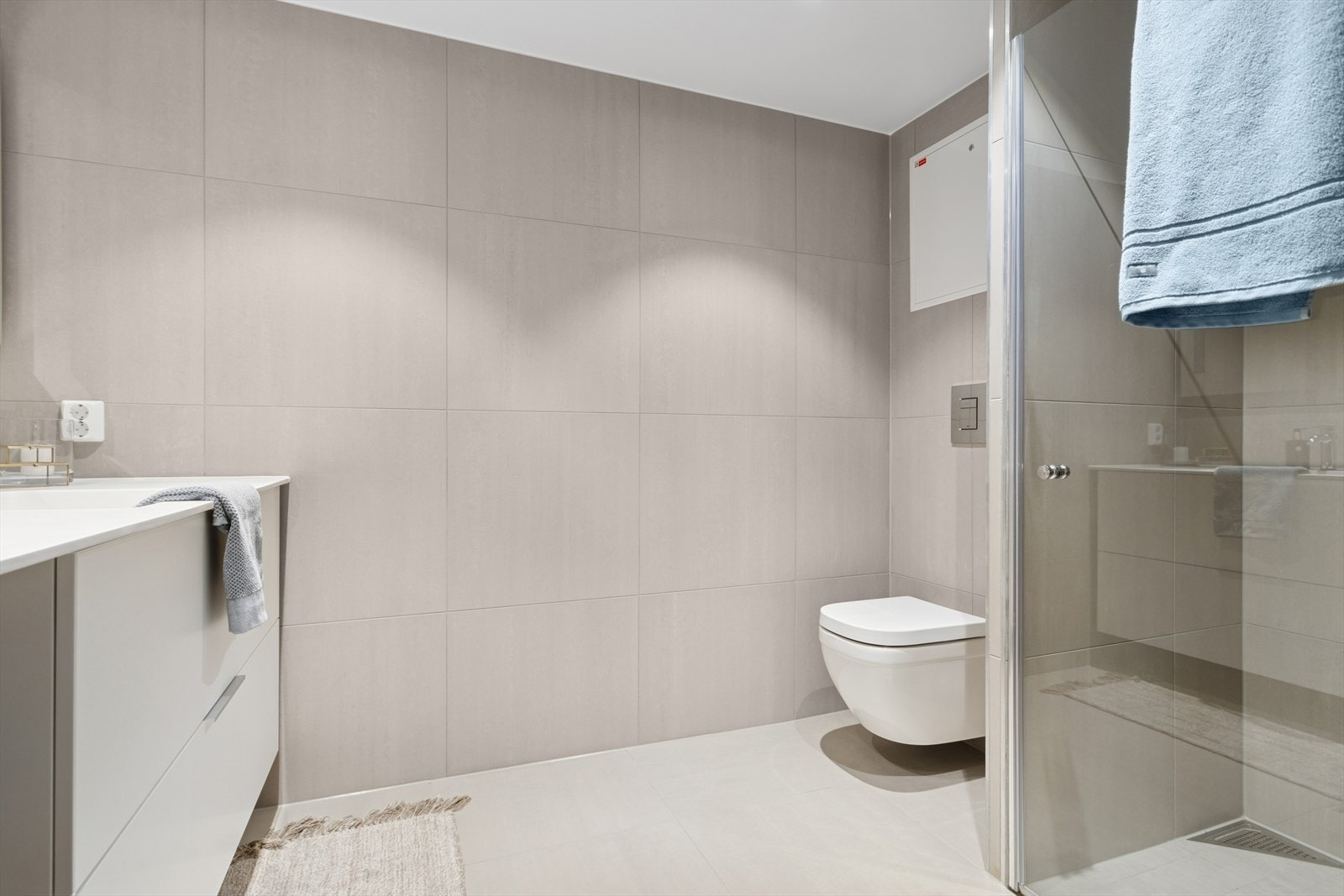 Badet har egen dusjnisje med rainshowerfunksjon, downlight i himling og vegghengt wc Galleribilde