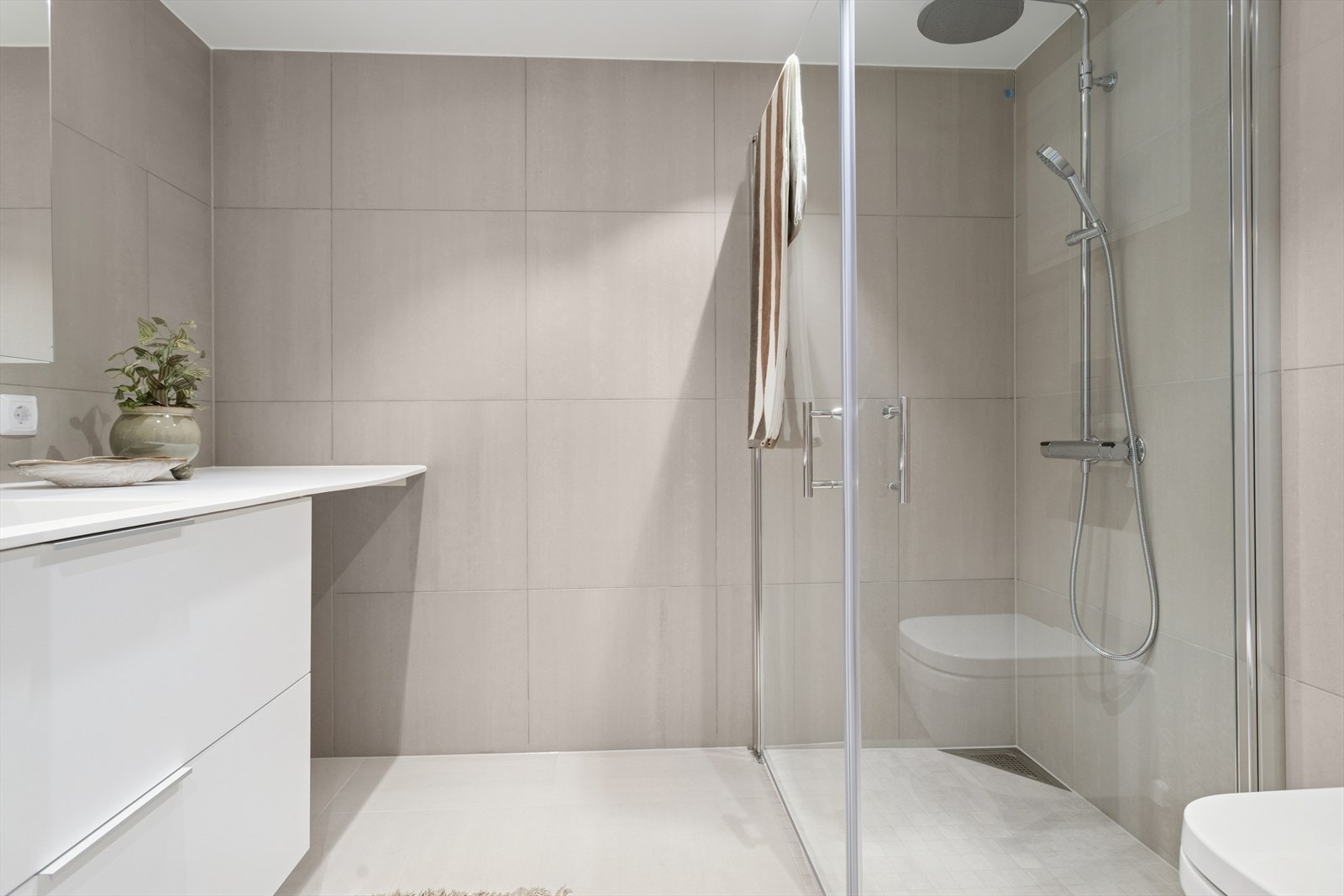 Dusjhjørne med rainshowerfunksjon, downlights i himling og vegghengt wc Galleribilde