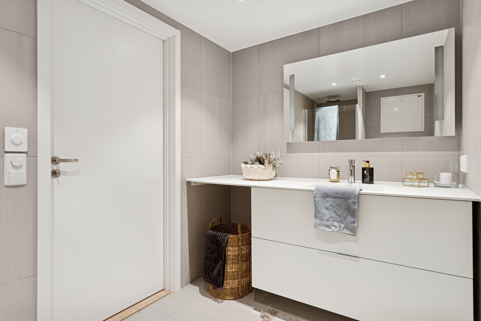 Moderne og flislagt (60x60) gjestebad i sokkeletasje med skuffer for oppbevaring og speil med lys Galleribilde