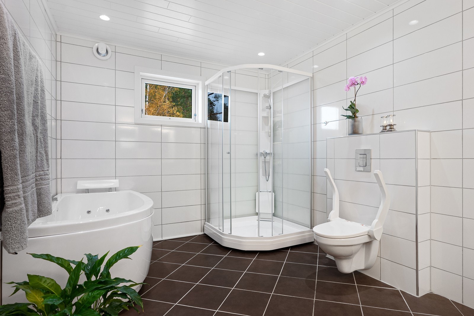 Rommet har vegghengt toalett, dusjkabinett og hjørnebadekar. Galleribilde