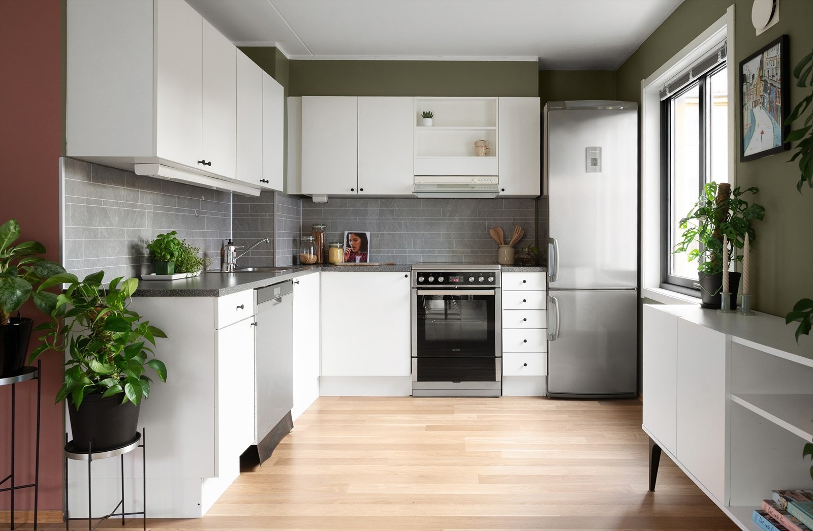 Lyst kjøkken med glatte fronter og laminat benkeplate. Galleribilde