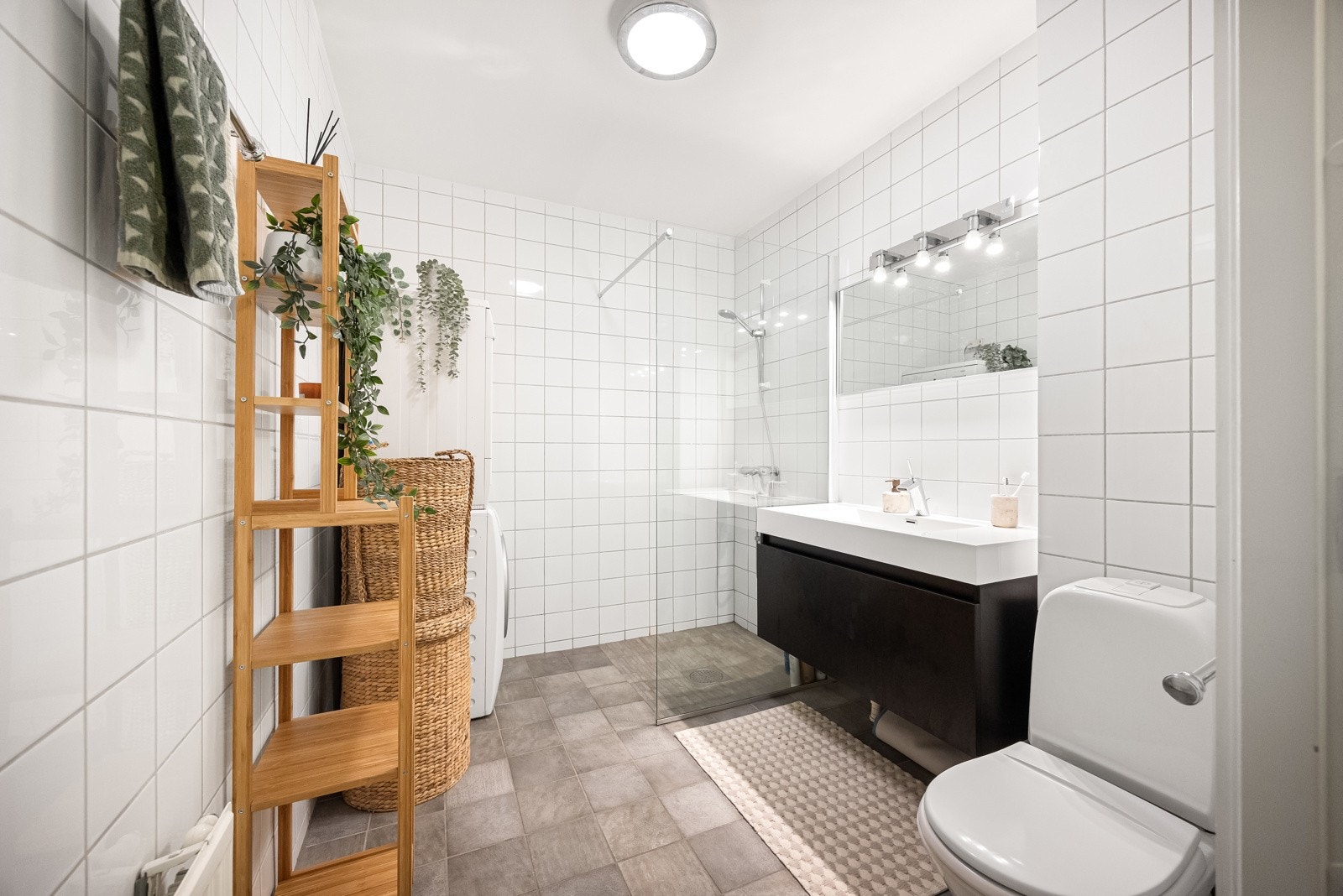 Badet er meget romslig med fliser på gulv og vegger, som kombinerer stil og funksjonalitet. Galleribilde