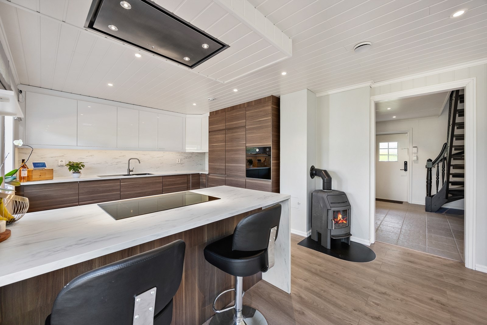 Et ildsted i stue- og kjøkkensonen gir både varme og en hyggelig atmosfære. Galleribilde