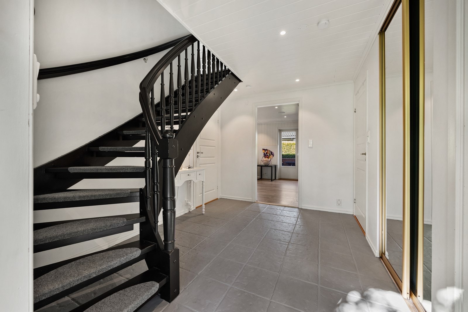 Den malte tretrappen med teppebelagte inntrinn binder etasjene elegant sammen. Galleribilde