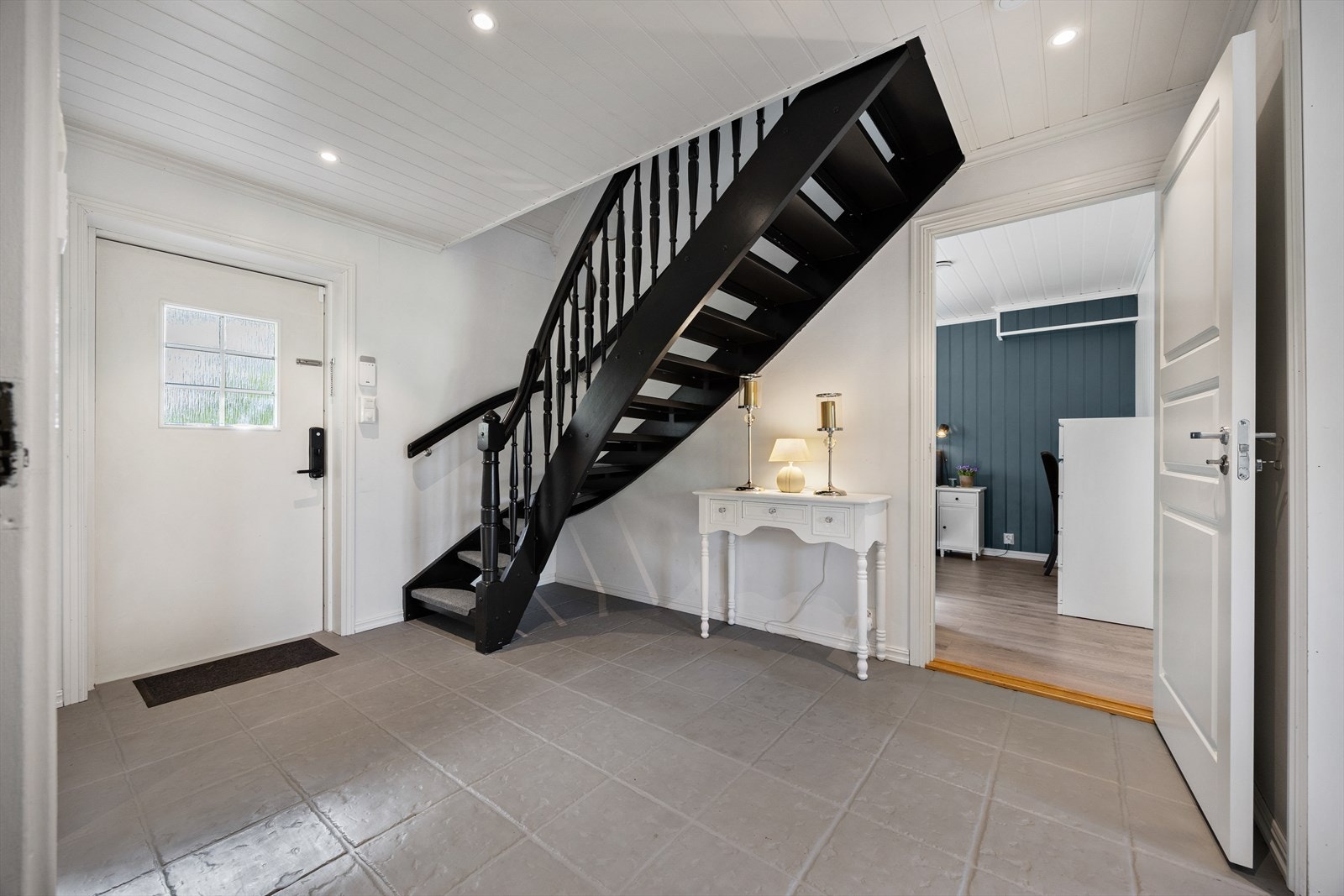 Velkommen inn i en romslig entré med flislagt gulv og adkomst til boligens øvrige rom. Galleribilde