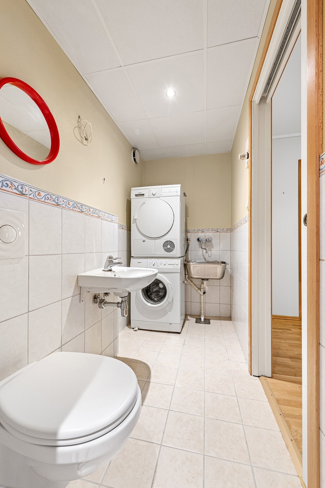 Kombinert bad/vaskerom med dusjnisje, vegghengt wc, servant, utslagsvask og opplegg for oppvaskmaskin og tørketrommel Galleribilde