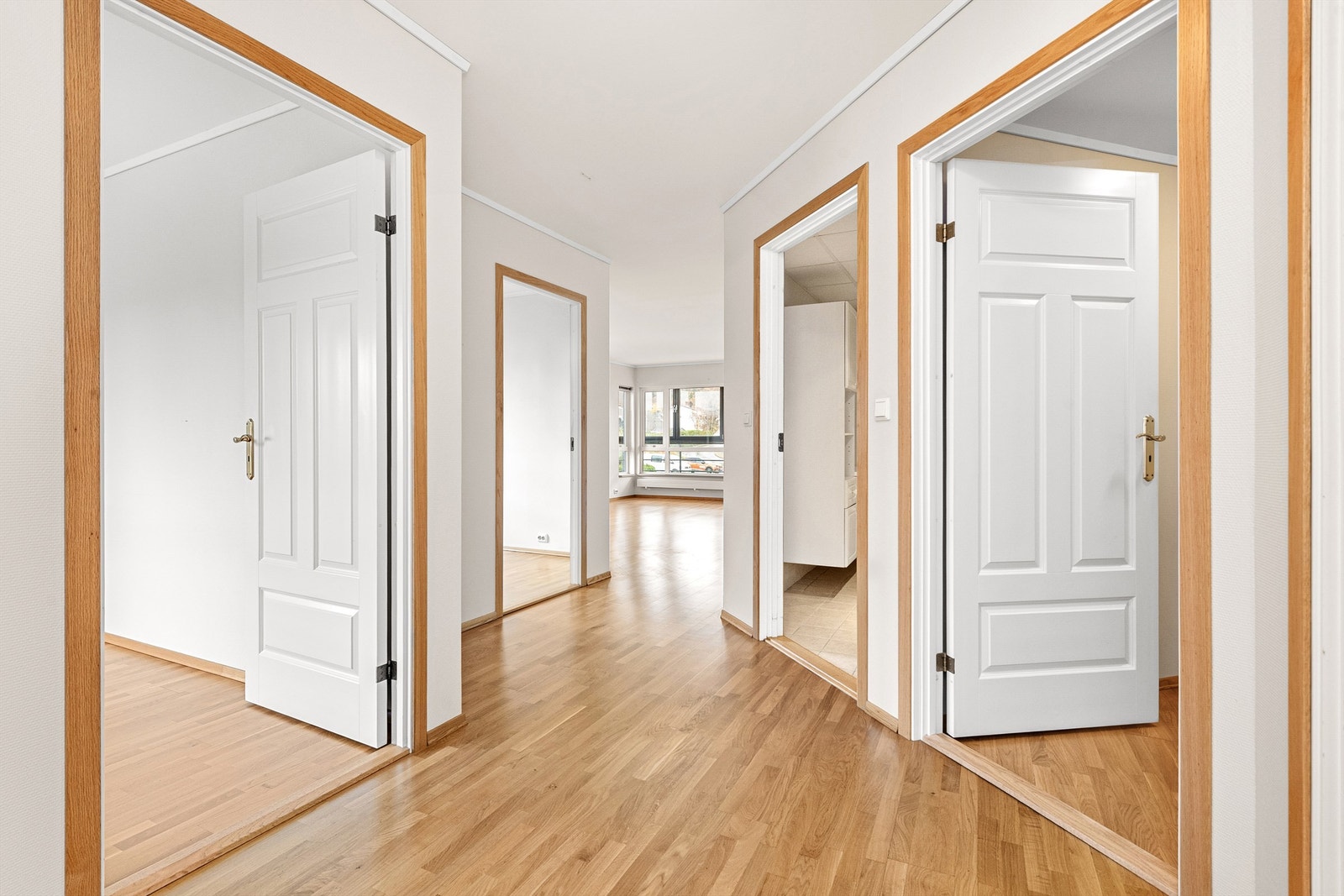 Romslig hall/gang med åpning mot stue. Hvite profilerte innerdører Galleribilde