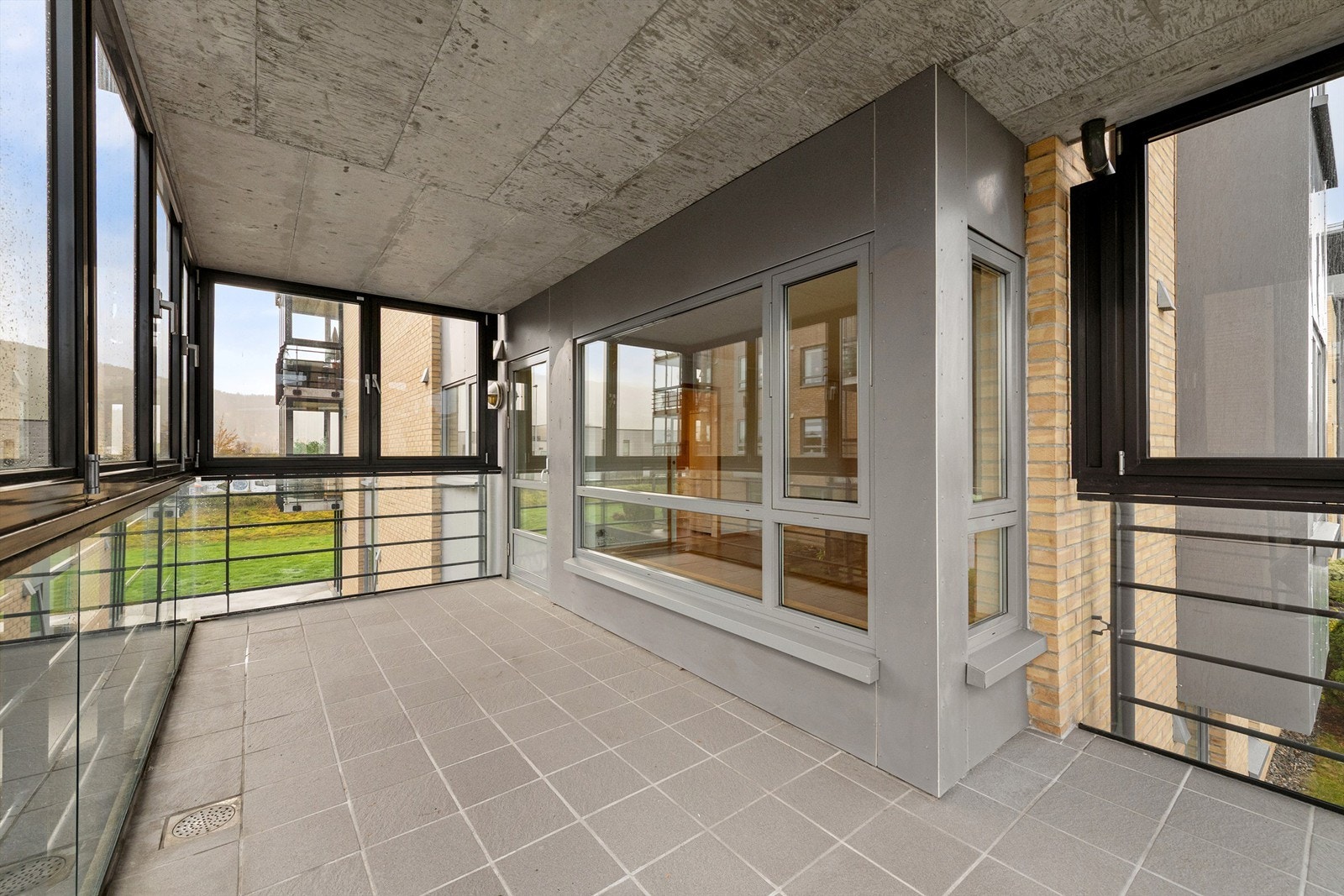 Romslig og innglasset balkong med god plass til flere soner og sitteplasser Galleribilde