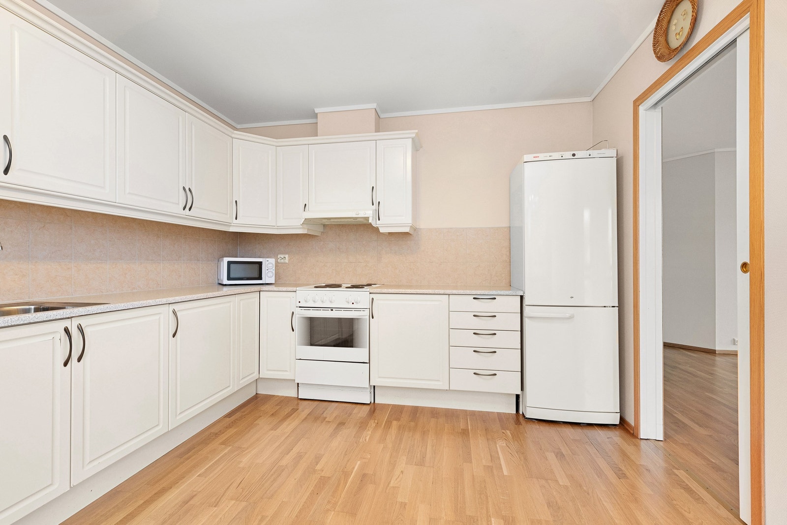 Kjøkkeninnredning med lyse profilerte fronter og benkeplate av laminat Galleribilde