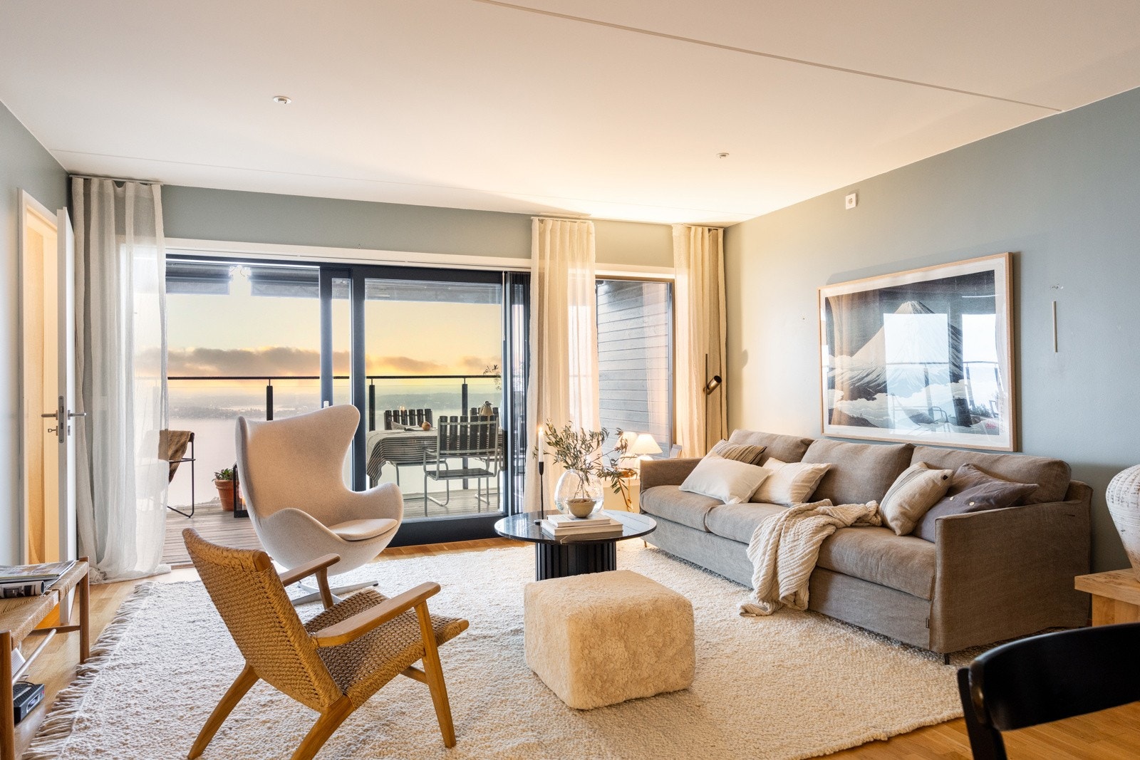 Stuen fremstår som lys og innbydende med store vindusflater som åpner opp mot utsikten. Her får man en luftig romfølelse og en behagelig atmosfære som inviterer til ro og trivsel Galleribilde