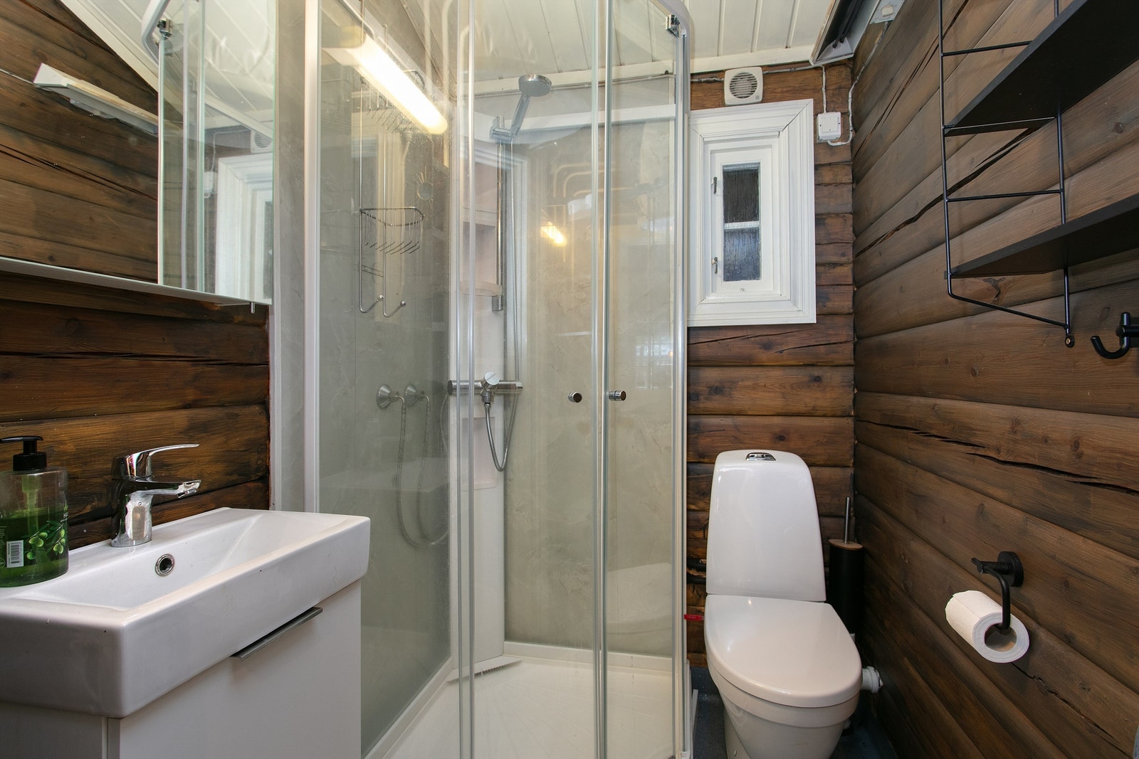 Bad med servantinnredning, speilskap, dusjkabinett og toalett Galleribilde