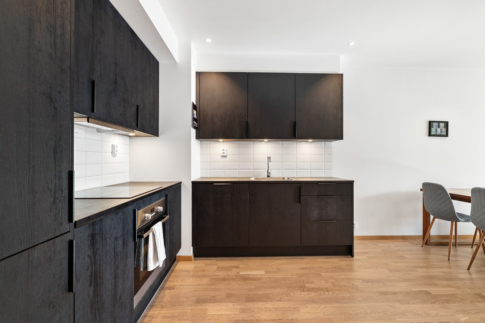 Flott kjøkken i sort utførelse med integrerte hvitevarer. Galleribilde