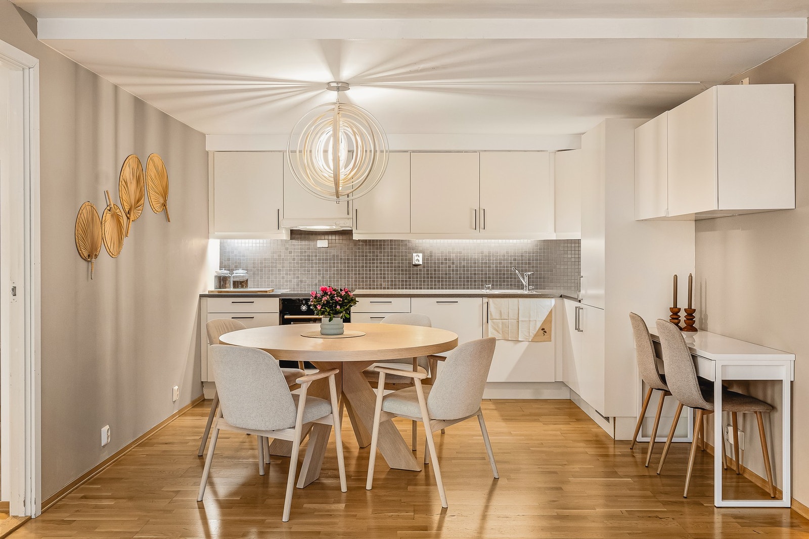 Pent og lyst kjøkken, med slette fronter og laminat benkeplate med stål oppvaskkum. Galleribilde