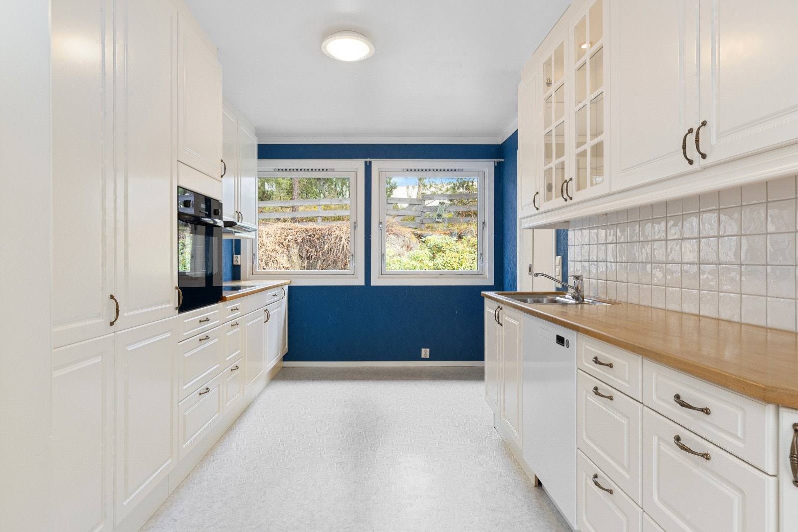 Praktisk kjøkken med god benkeplass og overskap som gir mye oppbevaring. Innredningen har profilerte fronter og benkeplater i treverk, vurdert til å være fra ca. 2001 Galleribilde