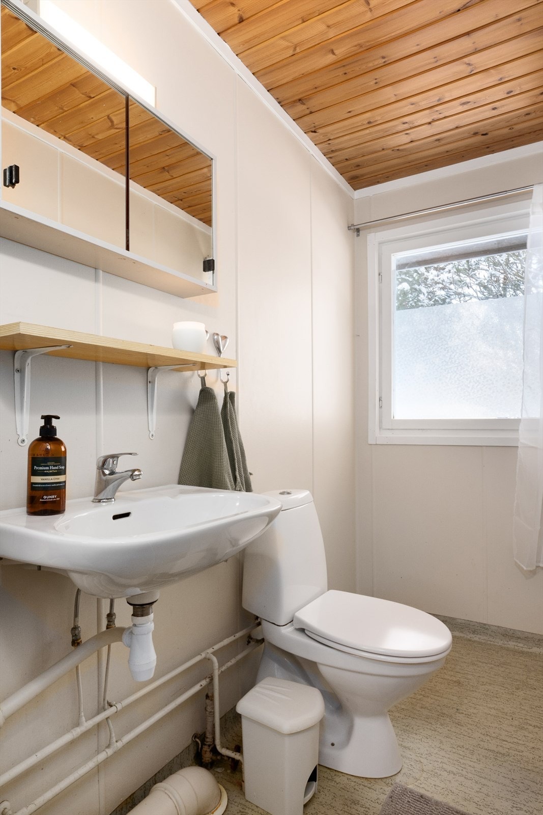 Separat toalettrom innredet med toalett og servant på vegg. Galleribilde