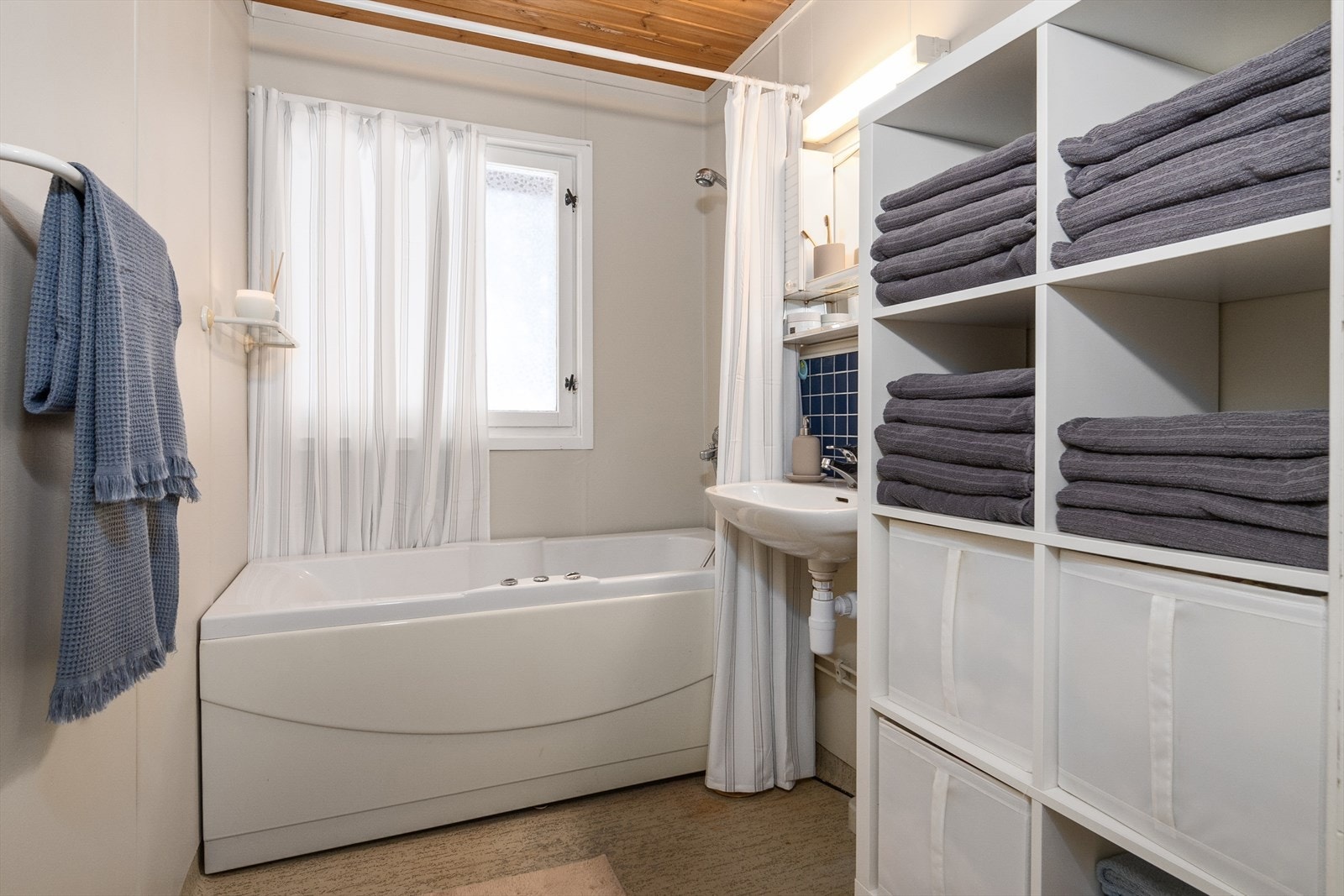 Badet er innredet med badekar, dusj på vegg og servant. Galleribilde