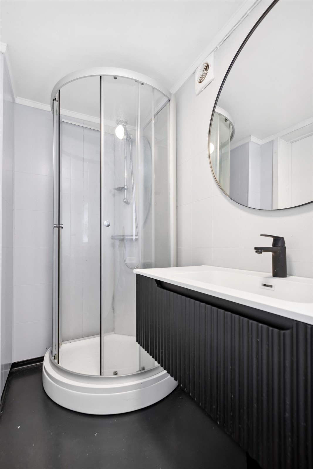 Rommet er innredet med servantinnredning, skap, dusjkabinett og toalett Galleribilde