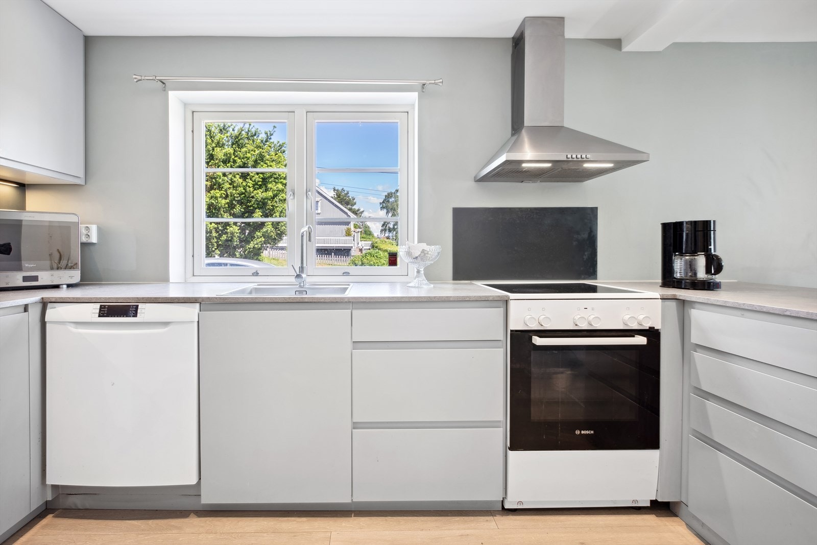 Innredningen har frittstående oppvaskmaskin og komfyr. Vinduet gir godt med arbeidslys til matlagingen Galleribilde