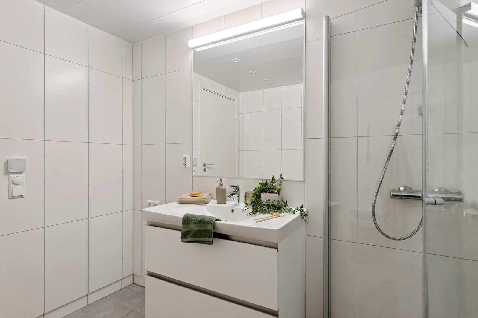 Moderne baderomsinnredning med heldekkende servant og god oppbevaringsplass. Galleribilde