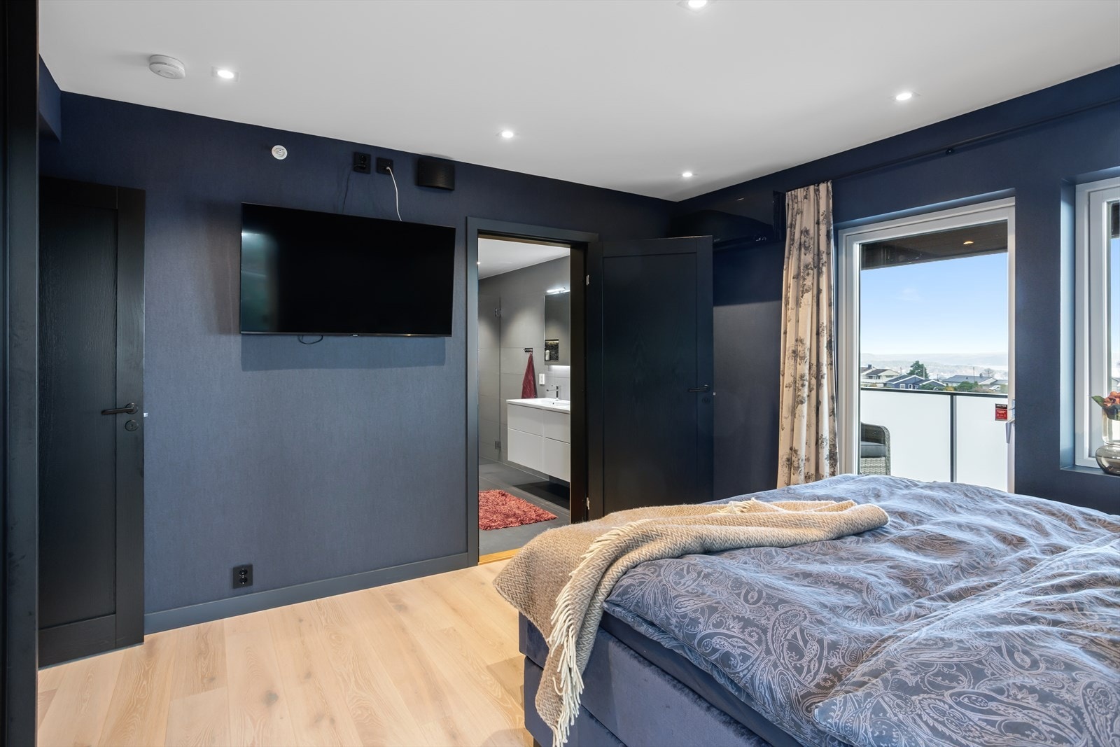 Hovedsoverommet ligger i en praktisk suiteløsning med direkte tilgang til både eget baderom og walk-in closet, samt utgang til balkong og terrassen - en privat og komfortabel oase i hjemmet. Galleribilde