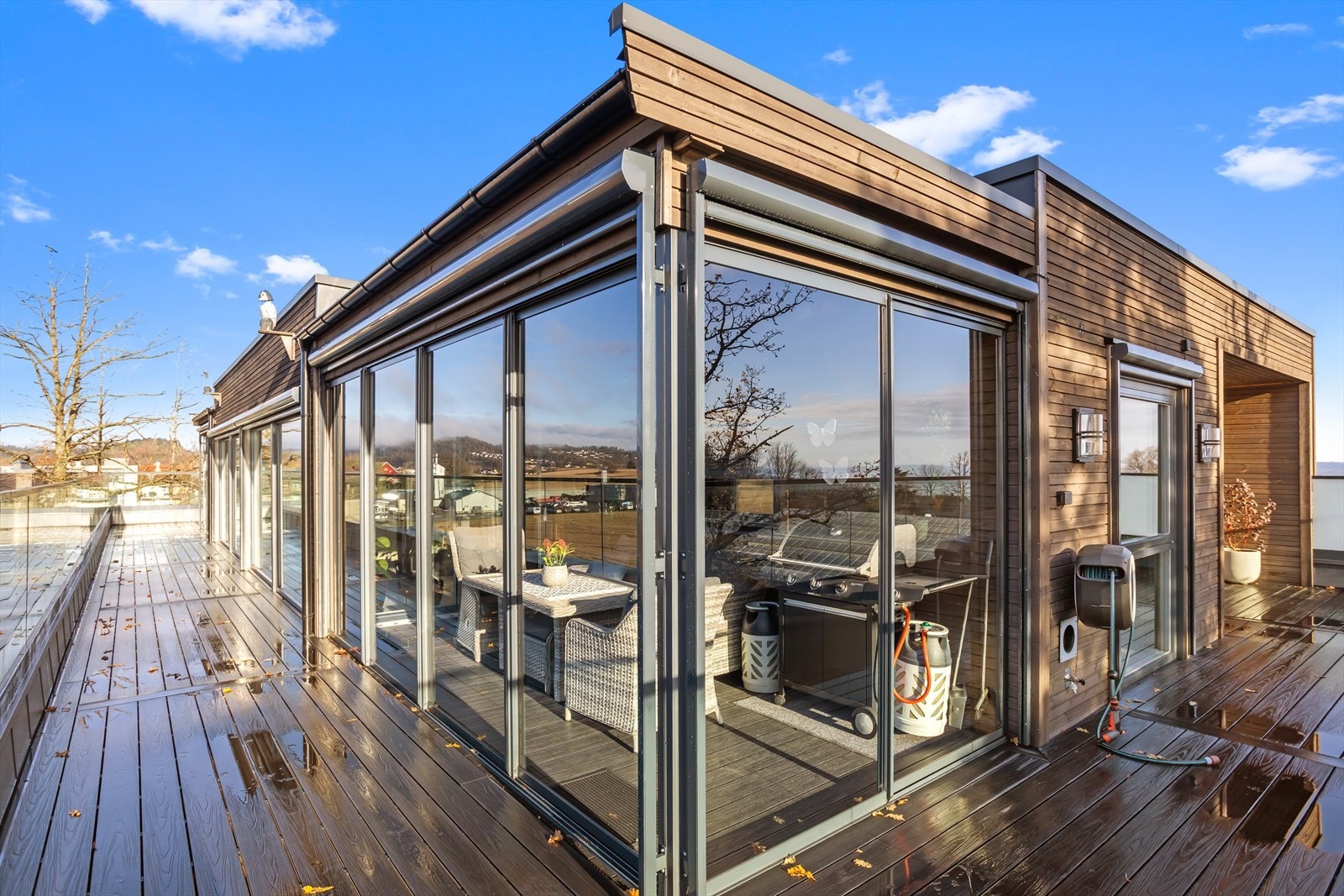 Den åpne terrassen har et imponerende areal med komposittgulv, glassrekkverk, utebelysning, stikkontakter og vannkran. Galleribilde