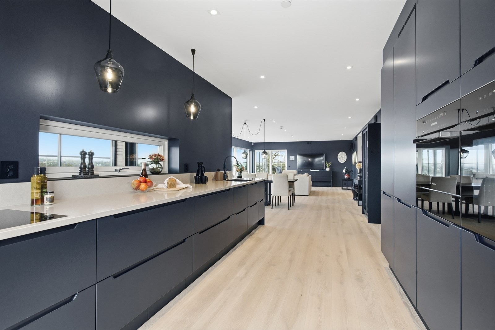 Det lekre HTH-kjøkkenet fremstår nærmest som skreddersydd, med praktiske høyskap langs én vegg og rikelig benke- og oppbevaringsplass på den andre. Galleribilde