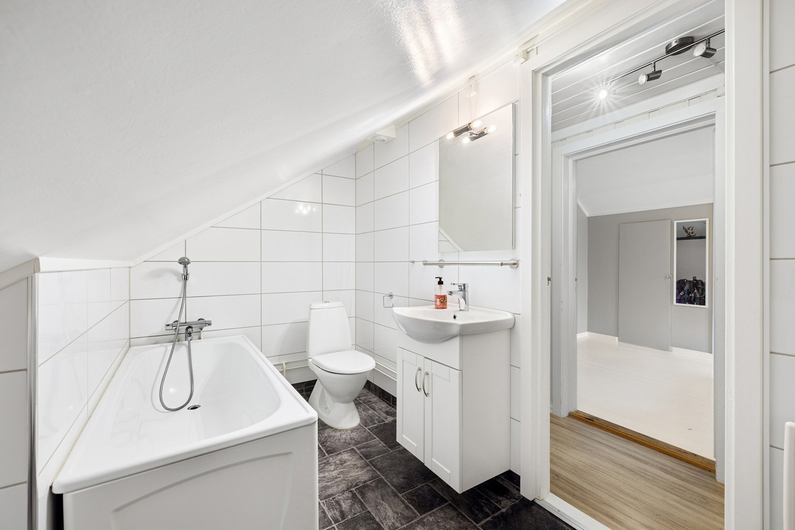 Lyst og pent bad i andre etasje, innredet med badekar, servant med underskap og toalett. Galleribilde