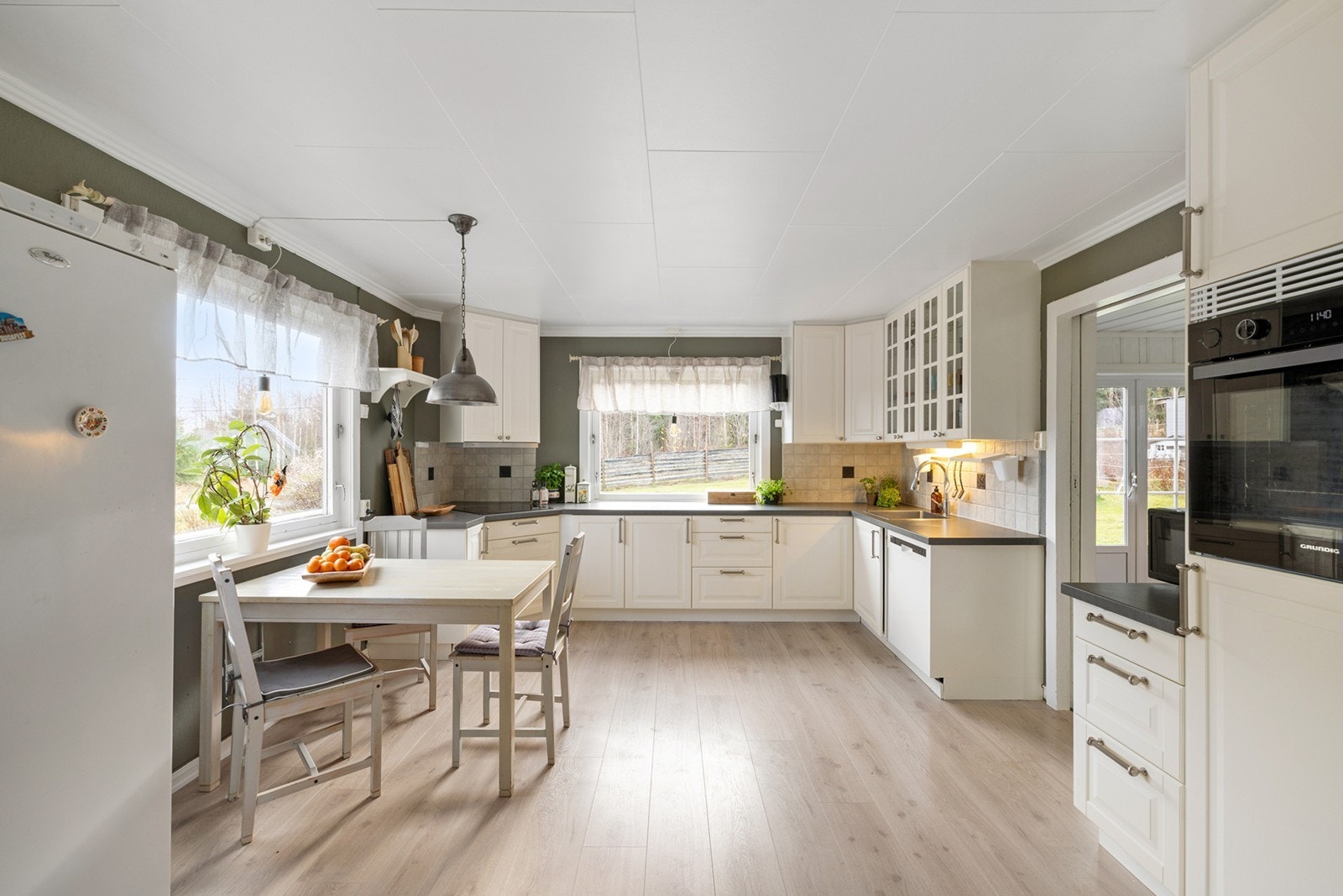 Lyst og romslig kjøkken med god plass til spisebord ved vinduet som slipper inn rikelig med naturlig lys. Galleribilde