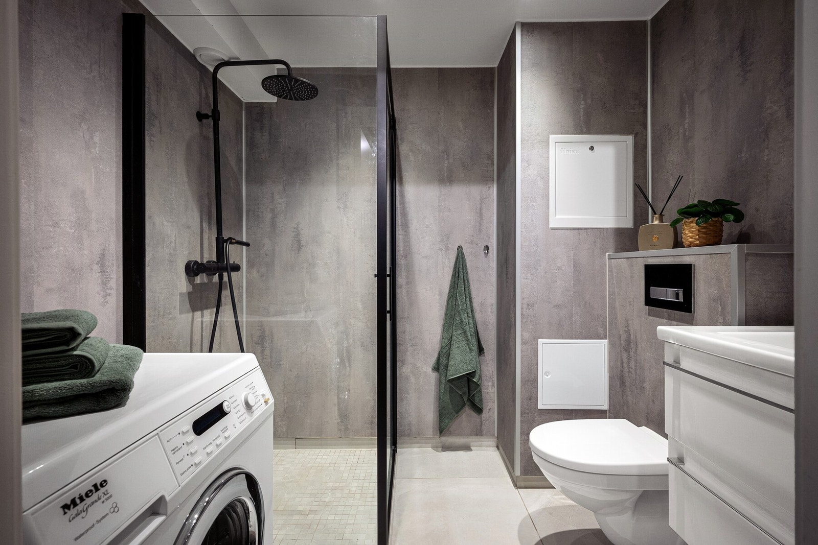 Badet er moderne og innbydende, og har en stilren utførelse med våtromsplater på vegg og fliser på gulv Galleribilde