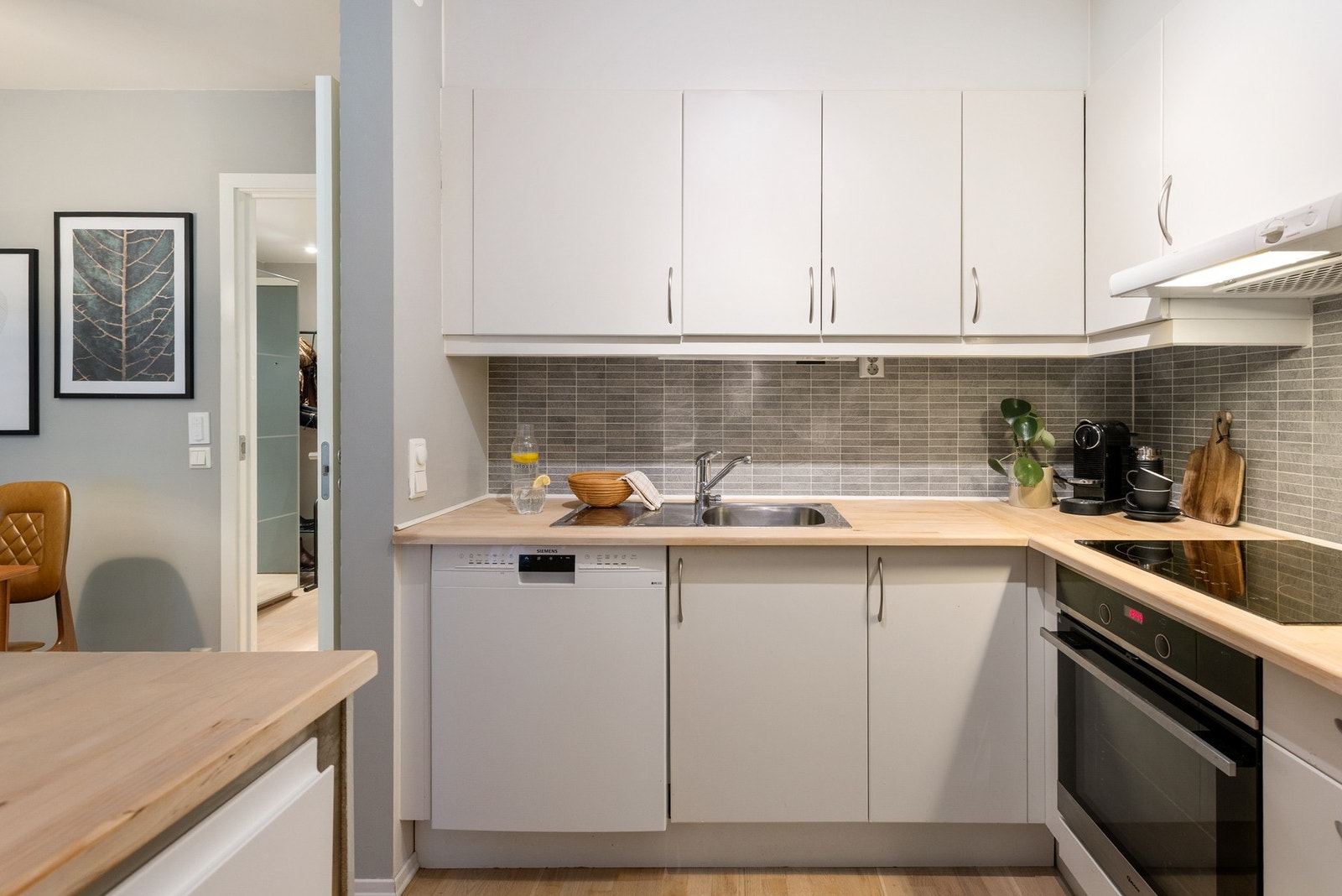 Kjøkkeninnredningen består av lyse, slette fronter med benkeplate i heltre og nedfelt oppvaskkum med ett-greps armatur. Galleribilde