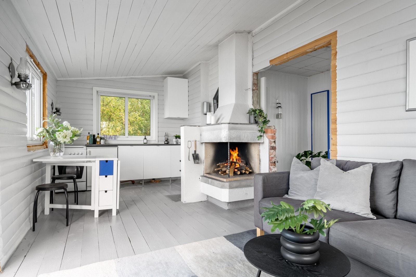 Stue og kjøkken ligger i åpen løsning og har lysmalte overflater, noe som skaper en luftig atmosfære Galleribilde