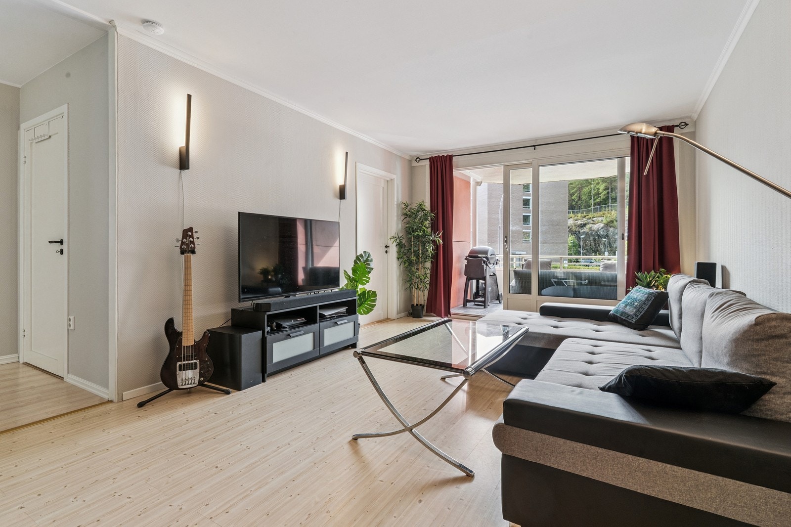 Lys og innbydende stue med sofagruppe, TV og store vindusflater. Galleribilde