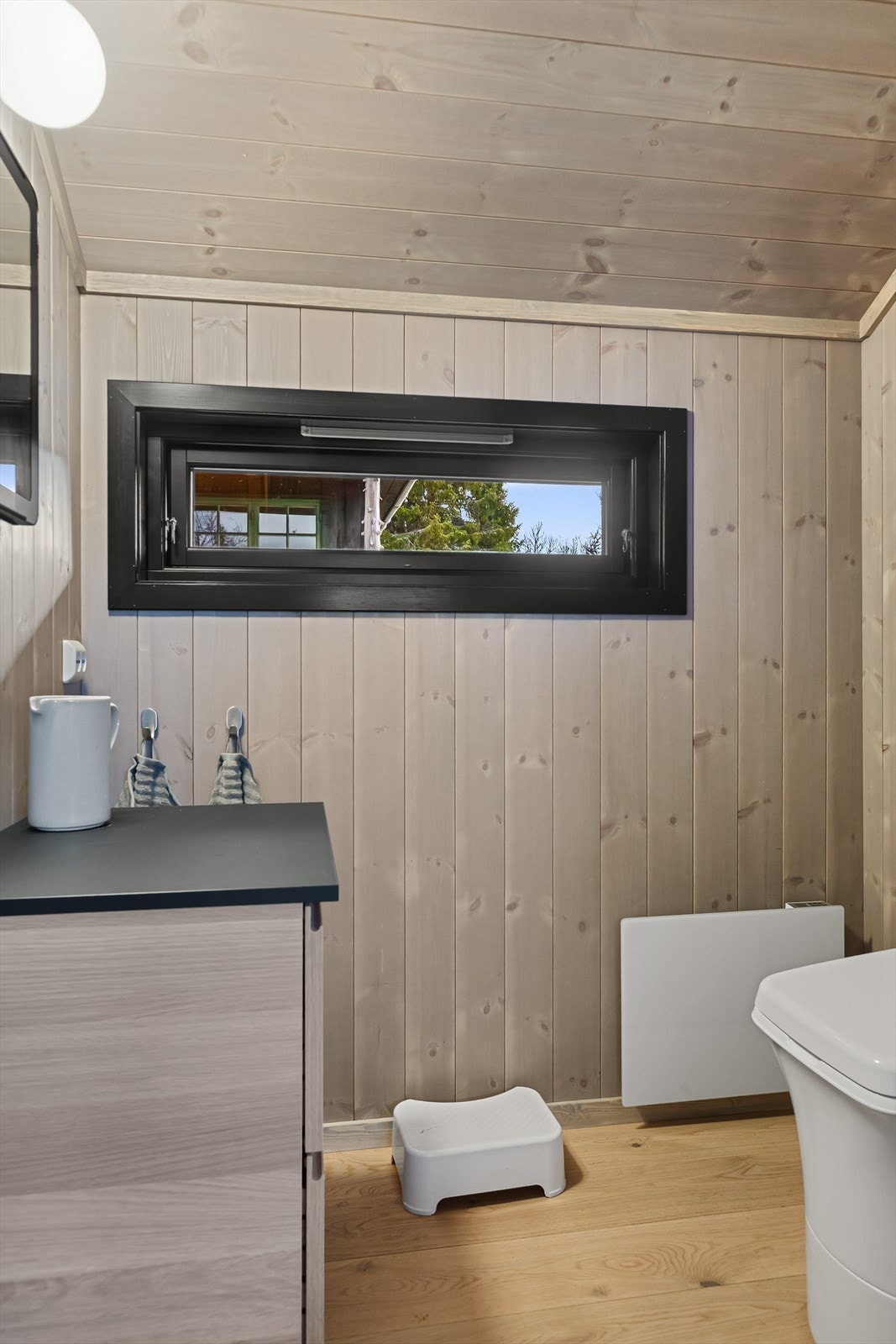 Det ene rommet er innredet som et praktisk toalettrom med benkeskap, speil og forbrenningstoalett. Galleribilde