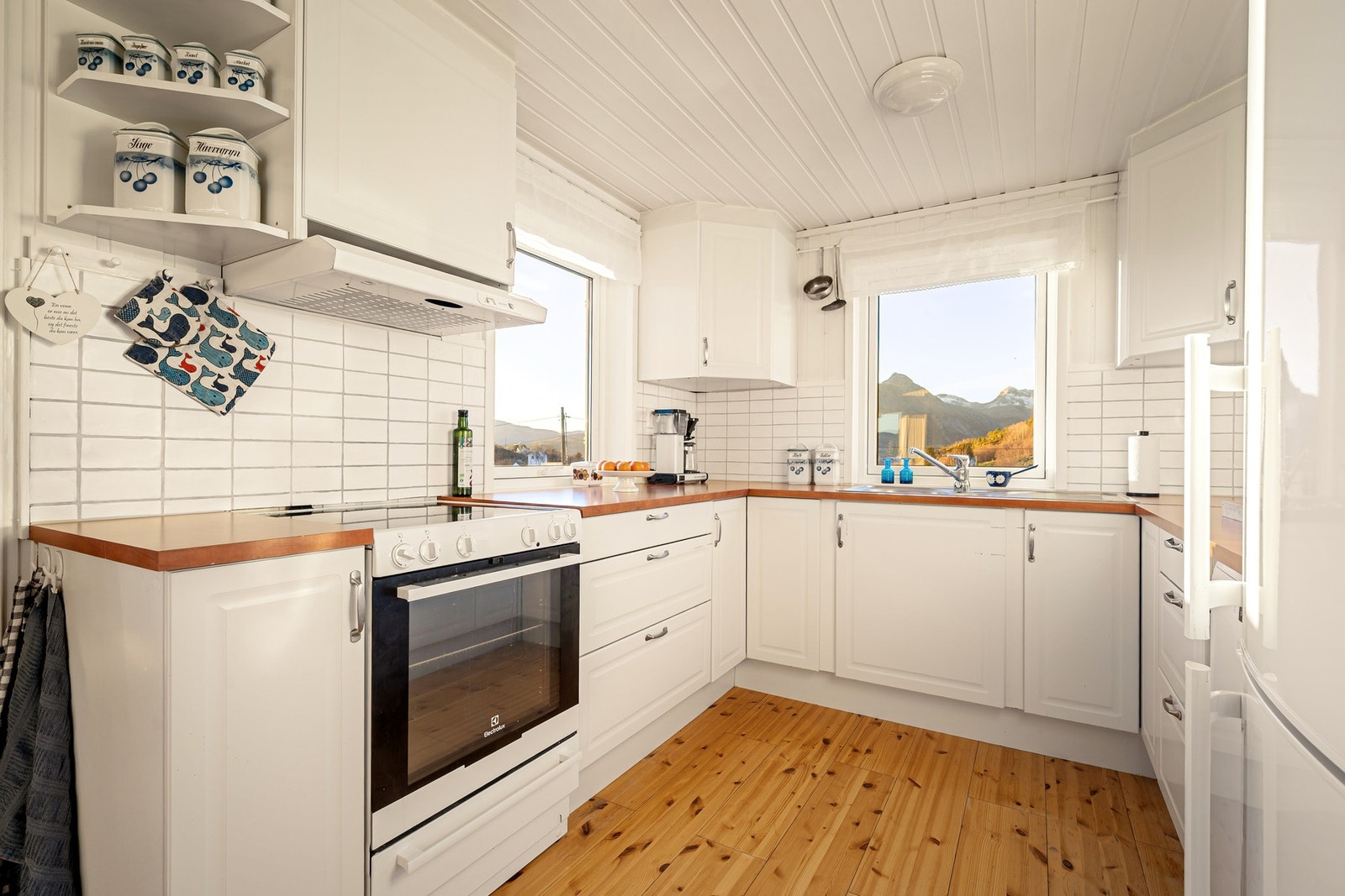 Kjøkkeninnredning i klassisk stil med lyse fronter, takhøye overskap, laminat benkeplate og kitchenboard Galleribilde