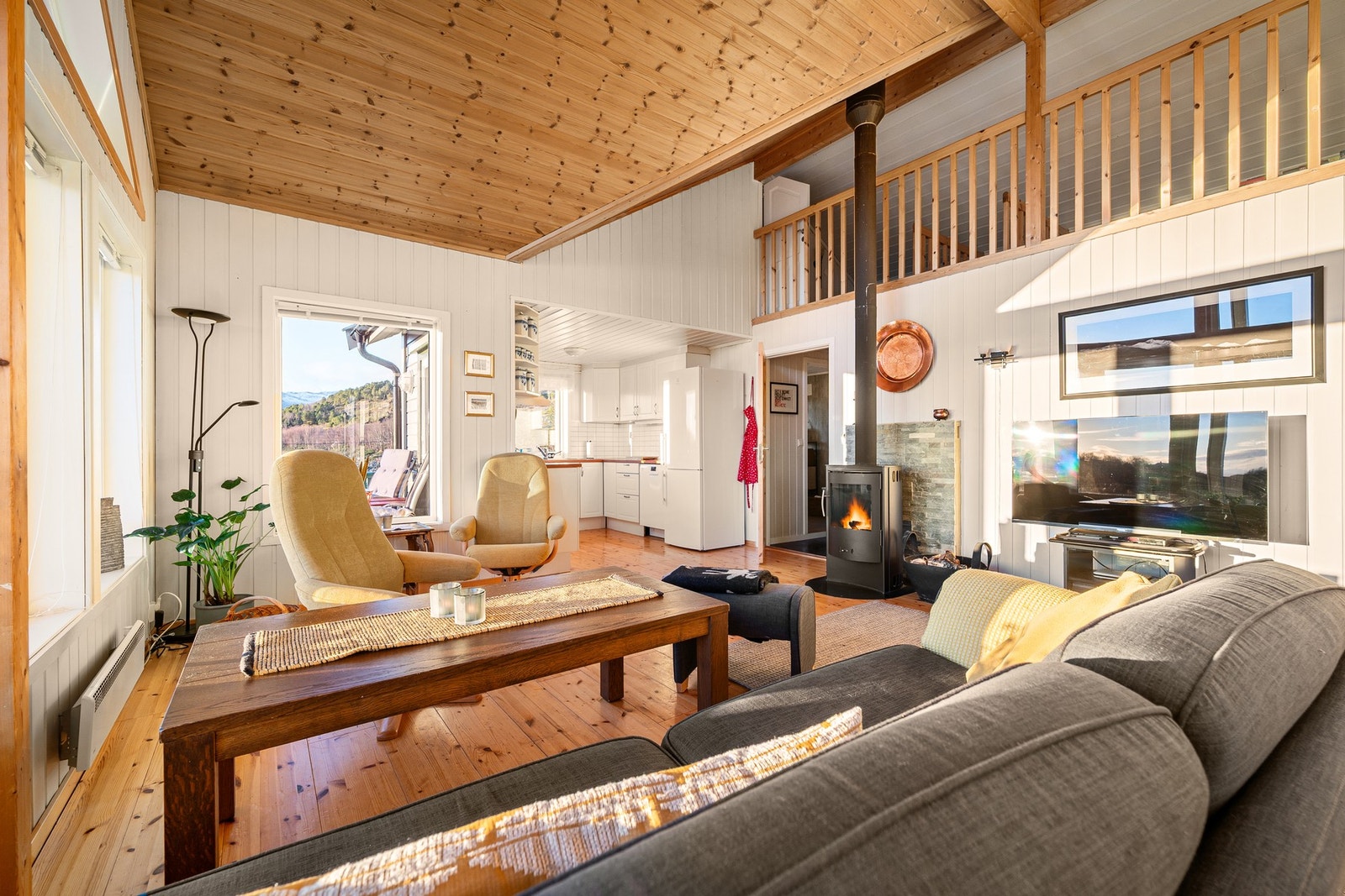 Lys og luftig stue med åpen løsning mot kjøkkenet, perfekt for sosialt samvær Galleribilde