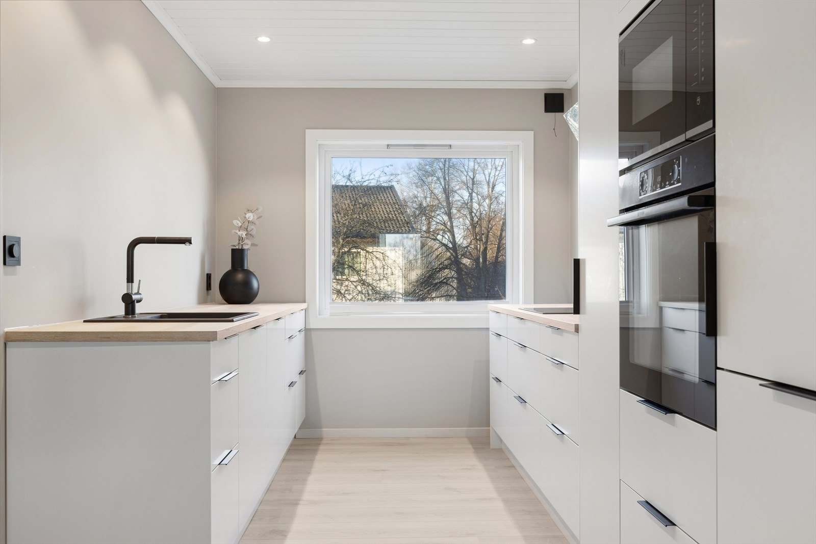 Lekkert kjøkken fra 2023, innredet med glatte fronter og laminat benkeplate. Integrerte hvitevarer medfølger i kjøpet Galleribilde