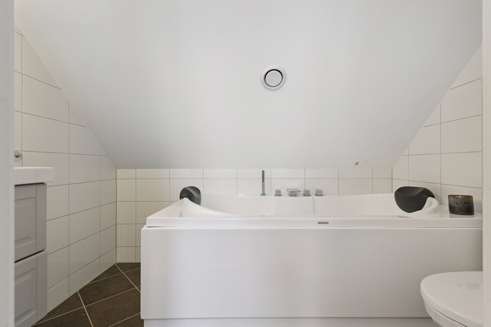 Badet på loftet er utstyrt med mekanisk avtrekk, servant, servantskap og veggmontert wc samt boblebad. badet er på 3m². Galleribilde