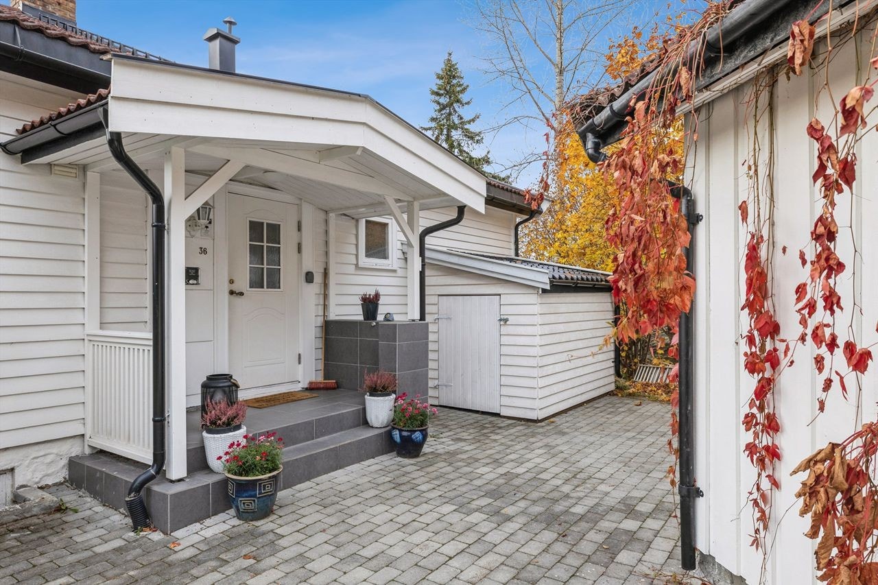 Et overbygget inngangsparti fører inn til boligens entré. Galleribilde